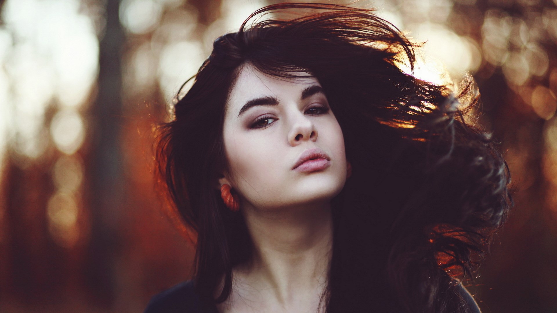 Woman with dark hair blowing in the wind HD Wallpaper