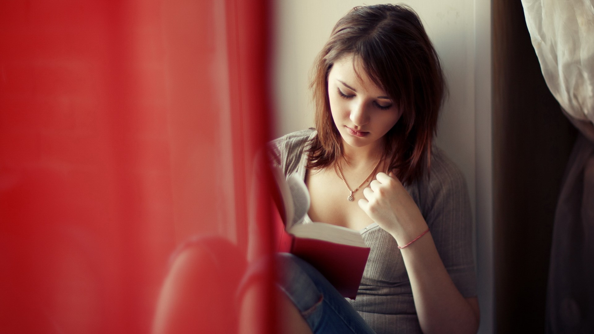 Young woman reading a book by a window HD Wallpaper