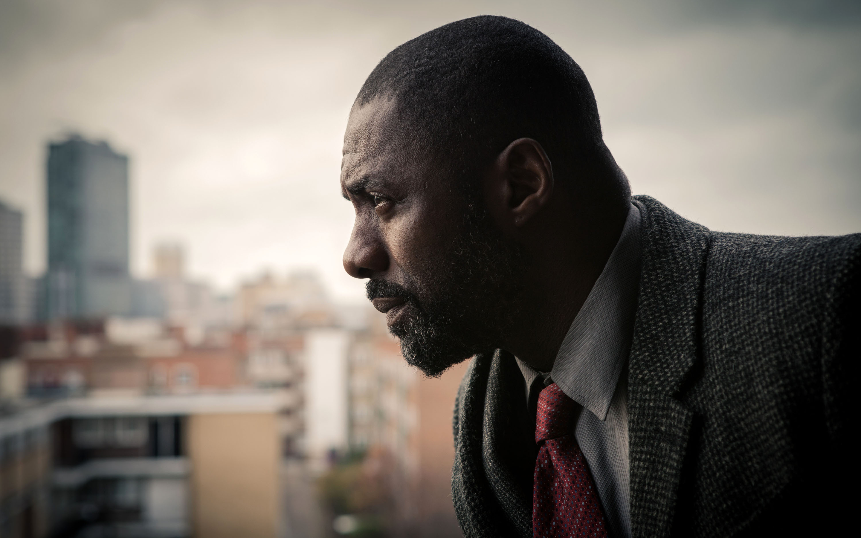 Idris Elba looking out over a city HD Wallpaper