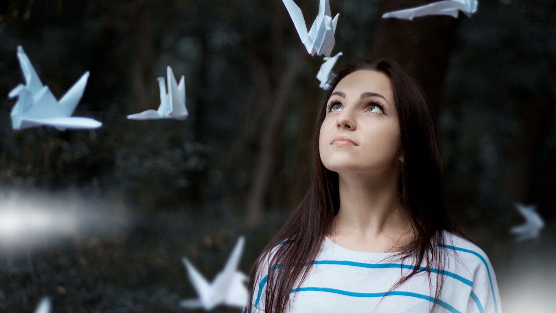 Woman looking up at origami cranes HD Wallpaper
