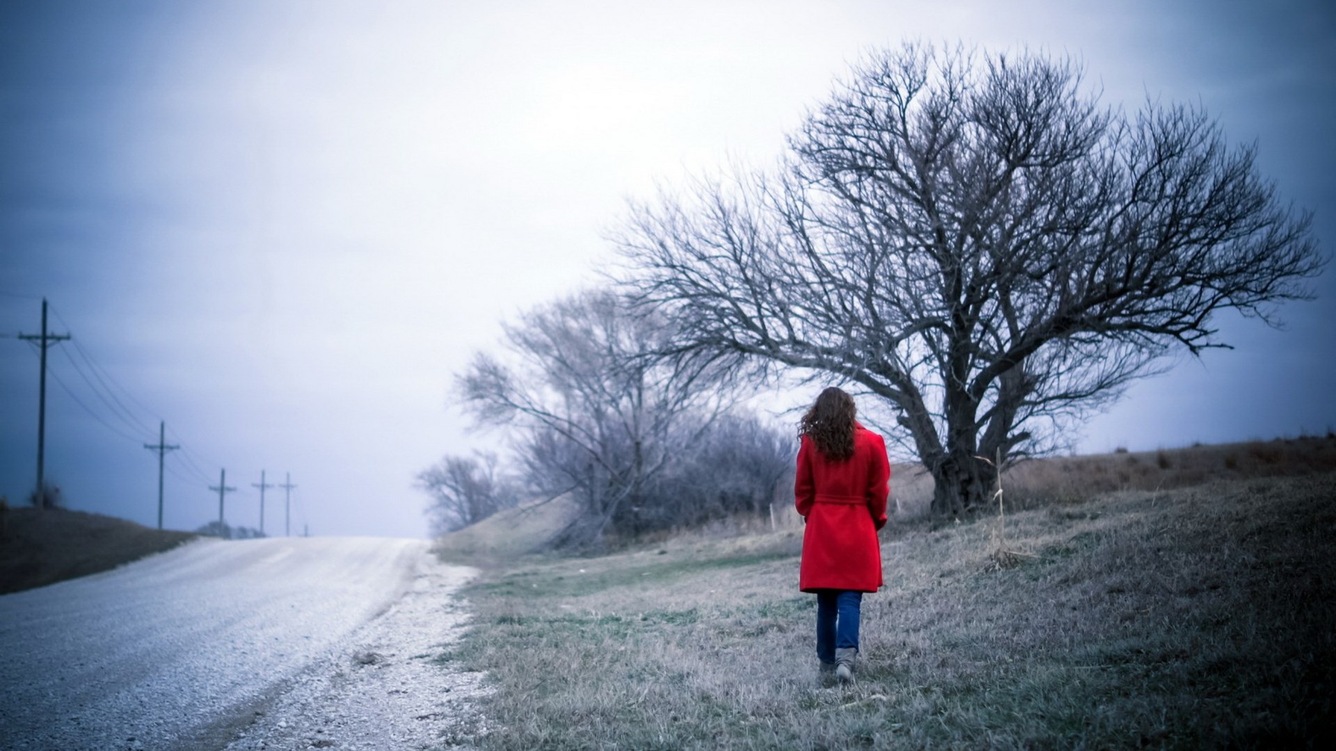 Woman in red coat walking on a dirt road HD Wallpaper