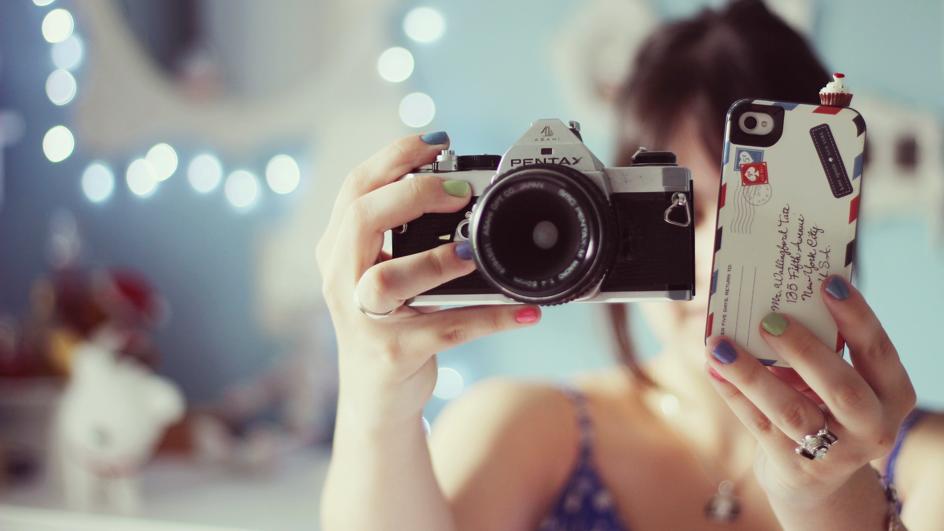 Woman holding Pentax camera and iPhone with cupcake case HD Wallpaper