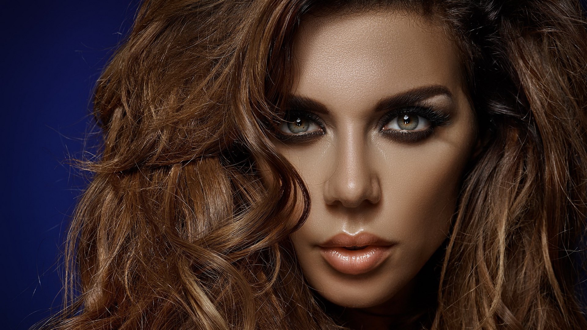 Woman with long wavy brown hair and dramatic makeup HD Wallpaper