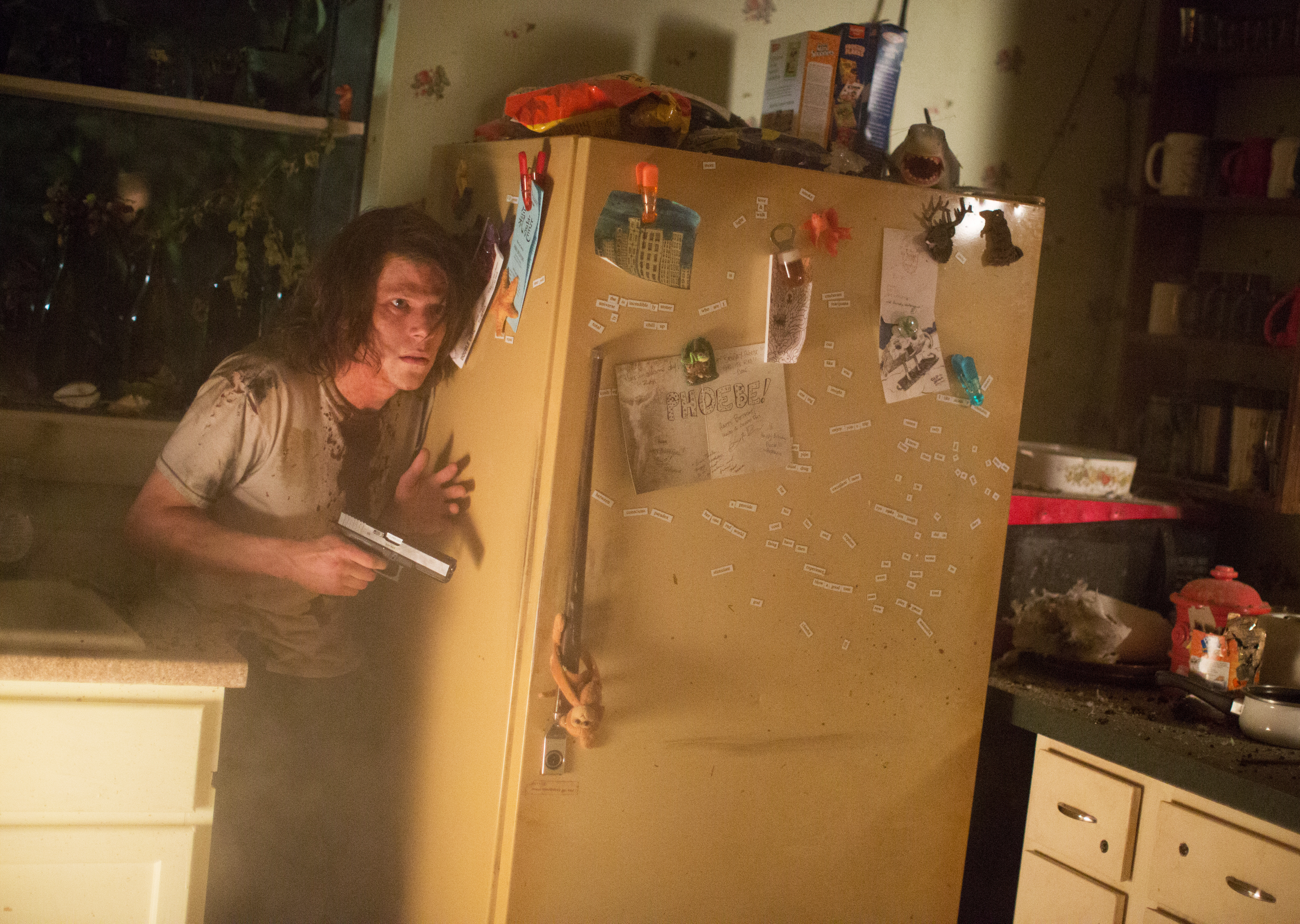 Jesse Eisenberg with a gun in a kitchen HD Wallpaper