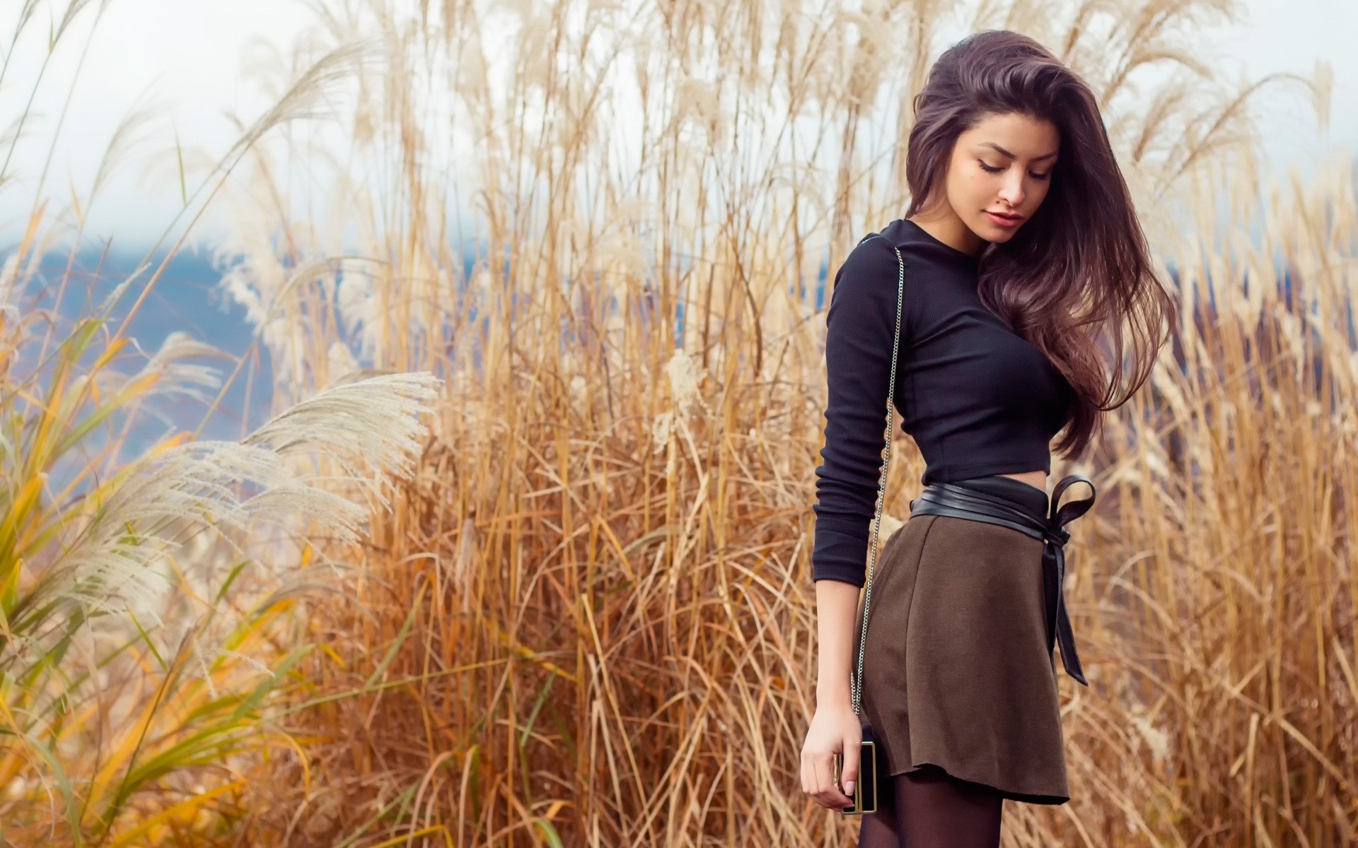 Woman in black top and brown skirt in tall grass HD Wallpaper