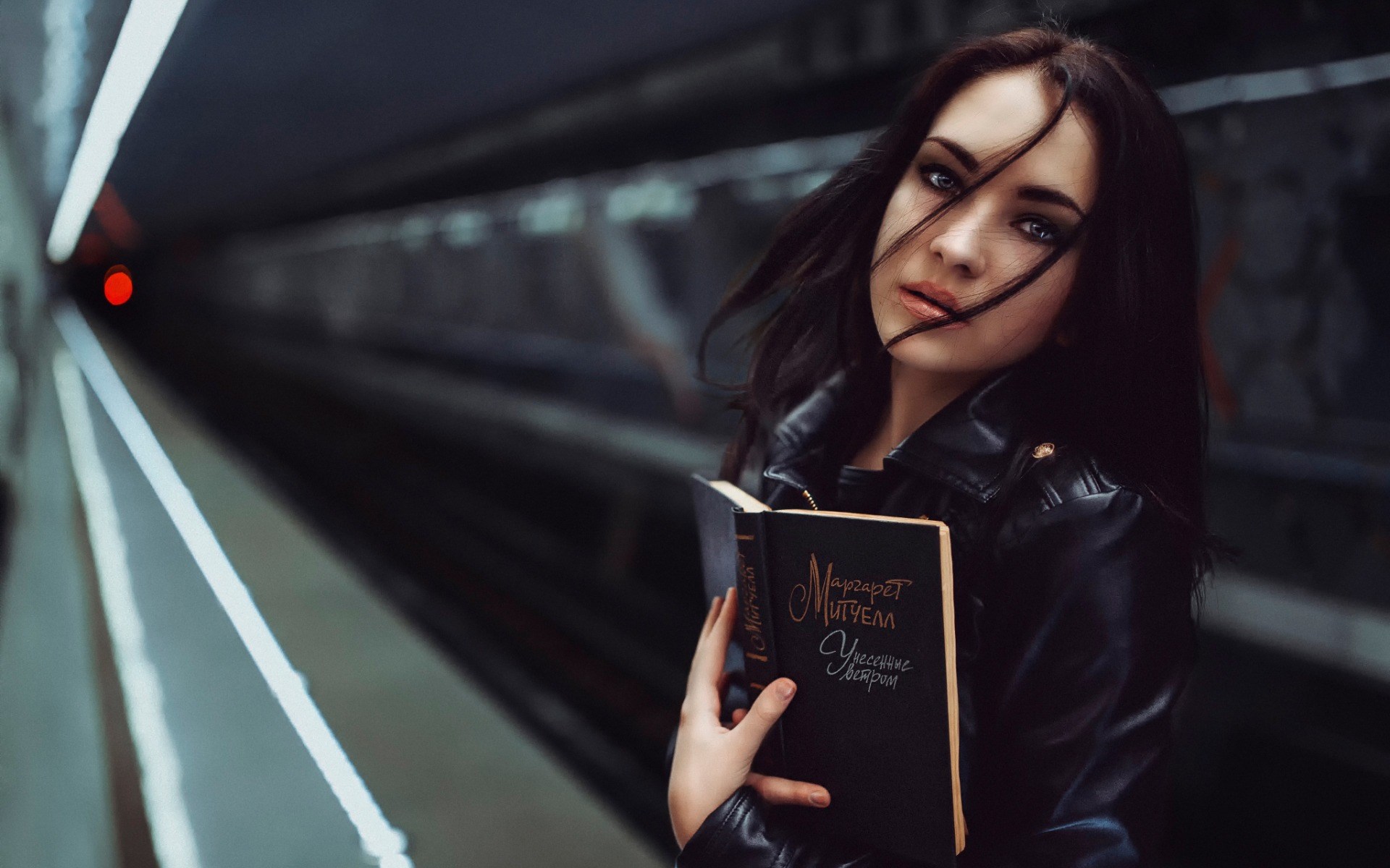 Woman holding a book on a subway platform HD Wallpaper