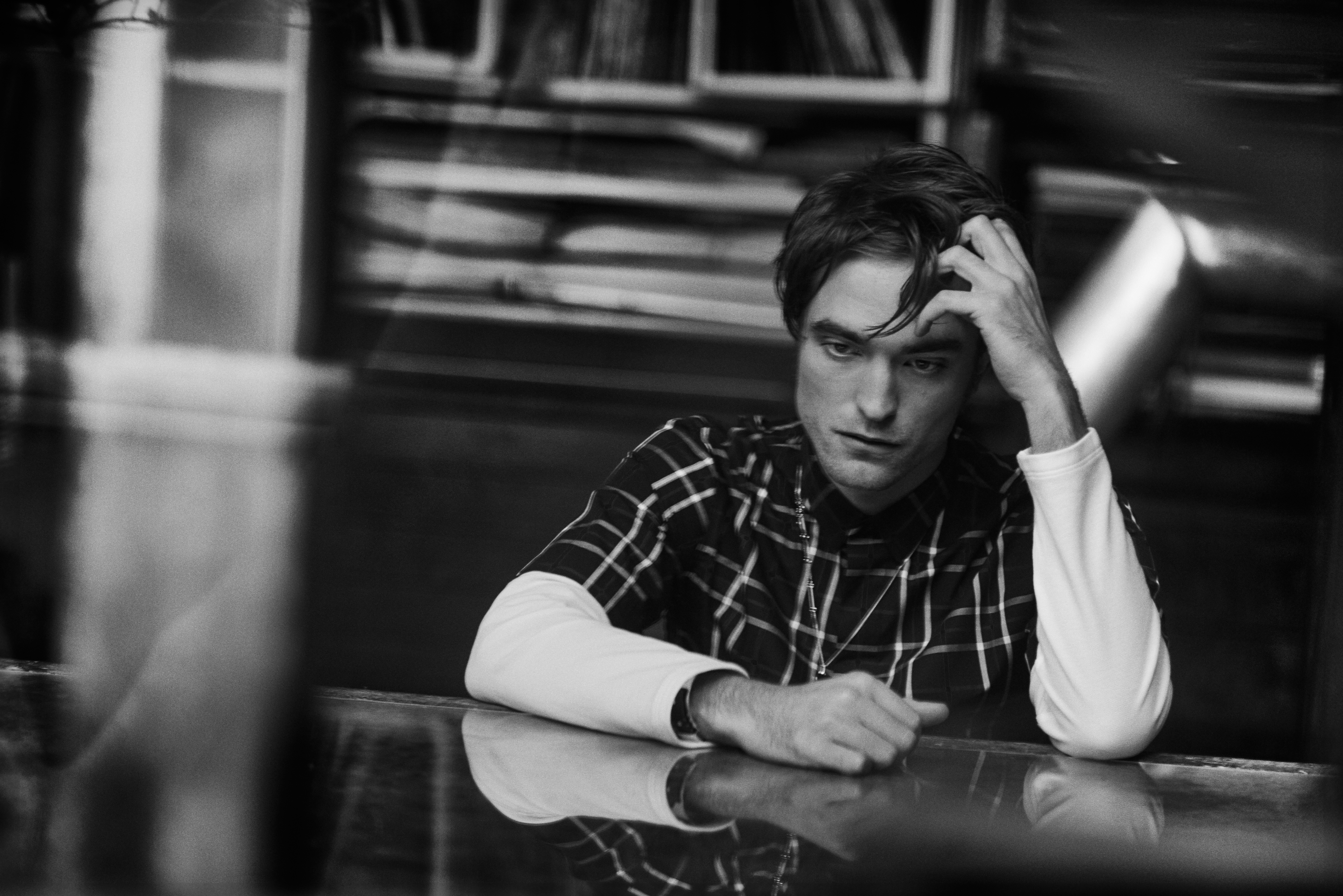 Robert Pattinson sitting at a table HD Wallpaper