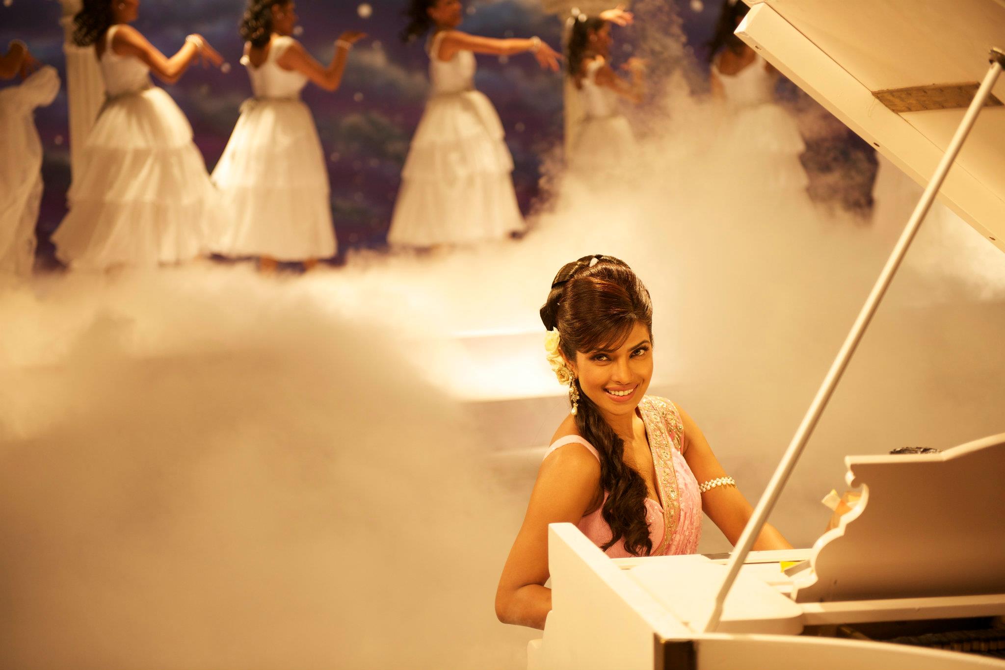 Priyanka Chopra playing piano with dancers in background HD Wallpaper