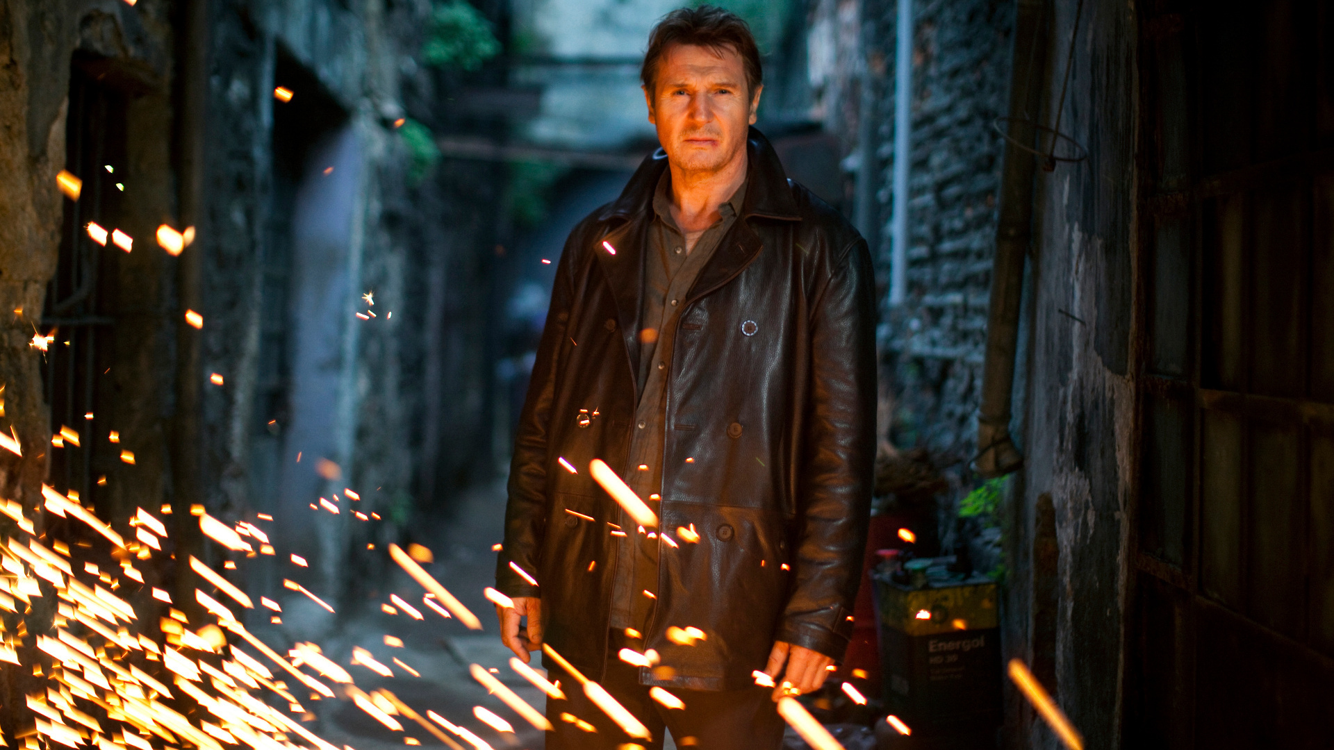 Liam Neeson in a dark alley with sparks HD Wallpaper