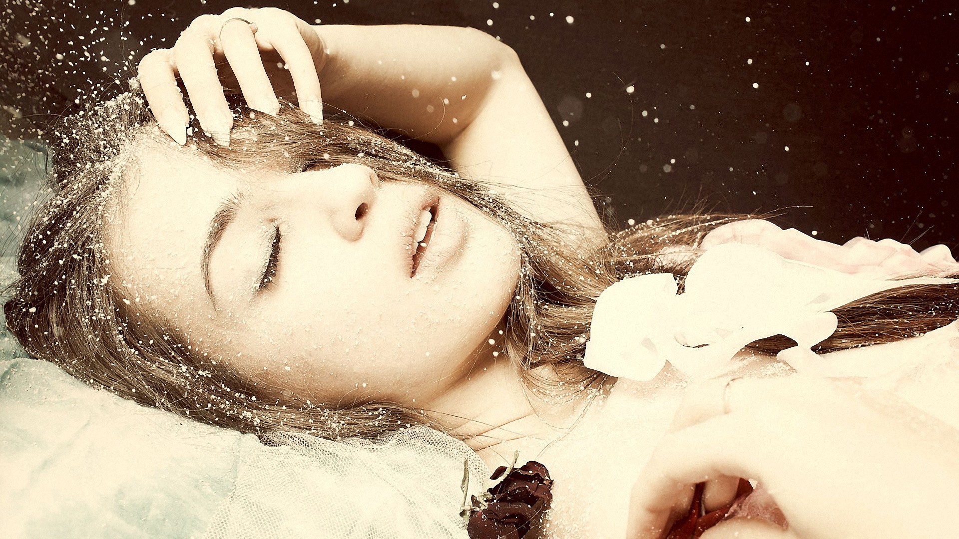 Woman lying down with snow on her face HD Wallpaper