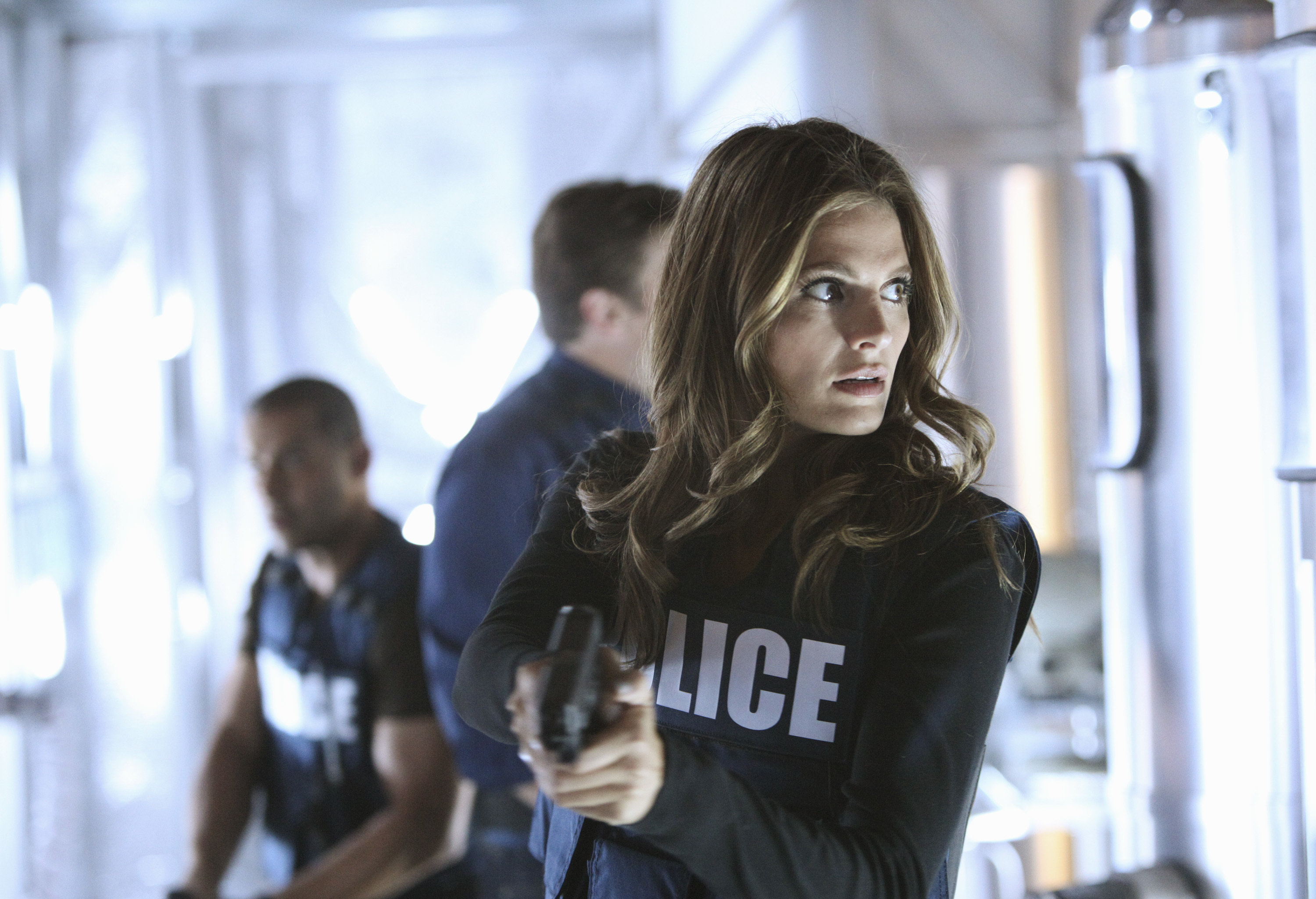 Stana Katic as a police officer holding a gun HD Wallpaper