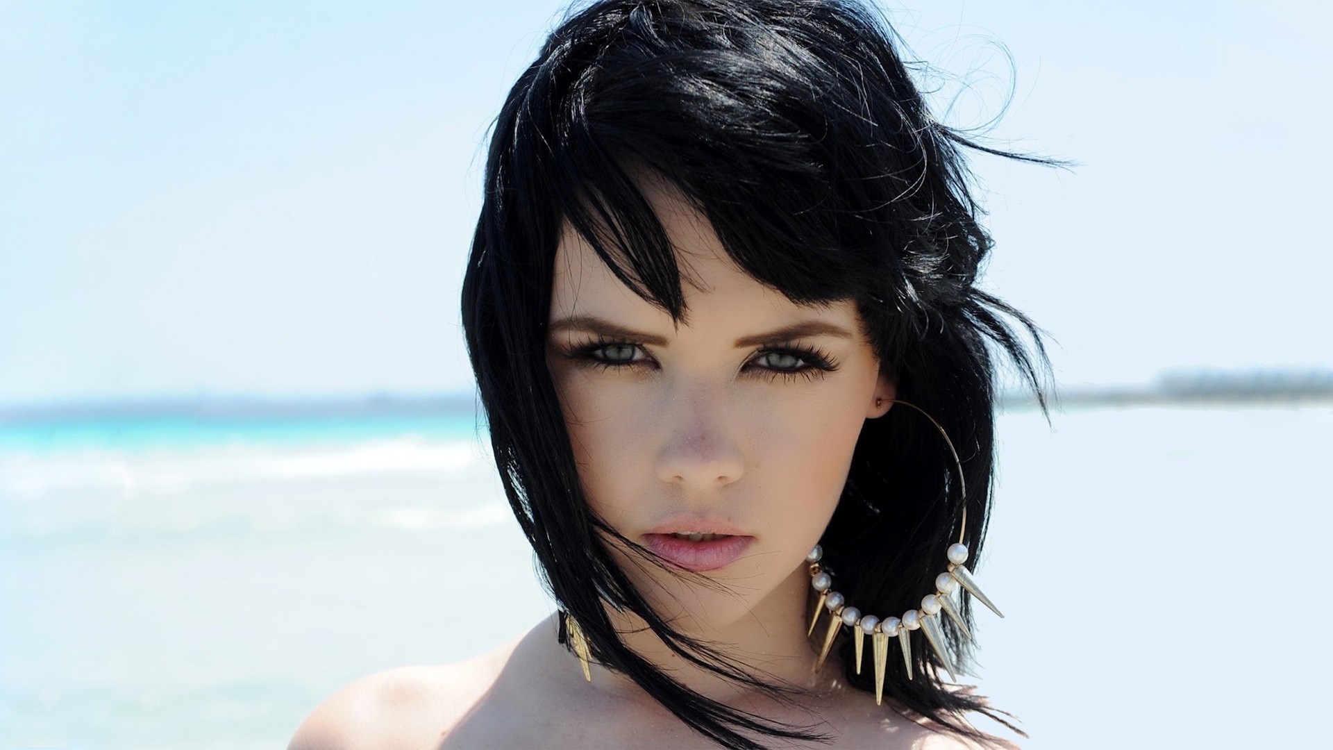 Woman with black hair and large earrings at the beach HD Wallpaper