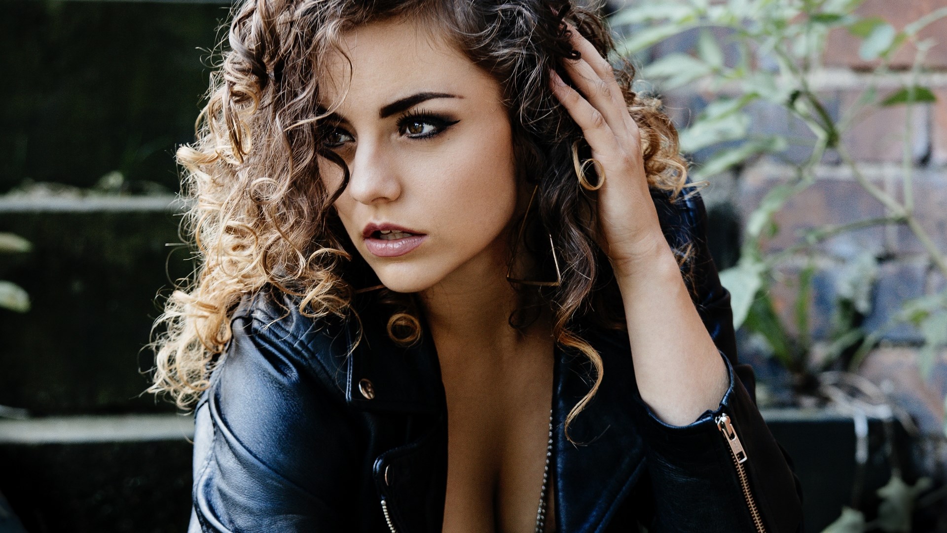 Woman with curly hair wearing a leather jacket HD Wallpaper