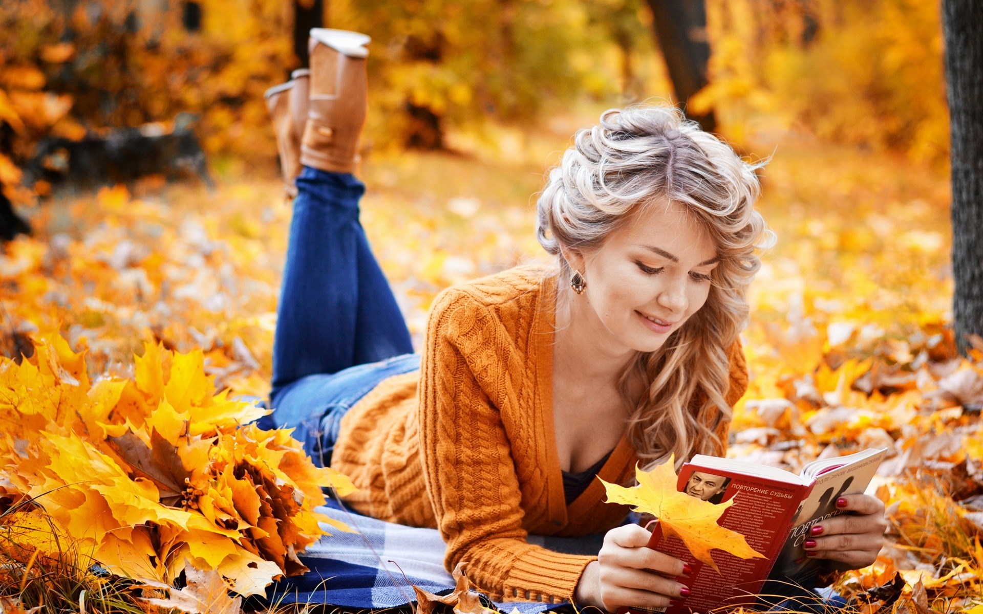 Woman reading a book in autumn leaves HD Wallpaper