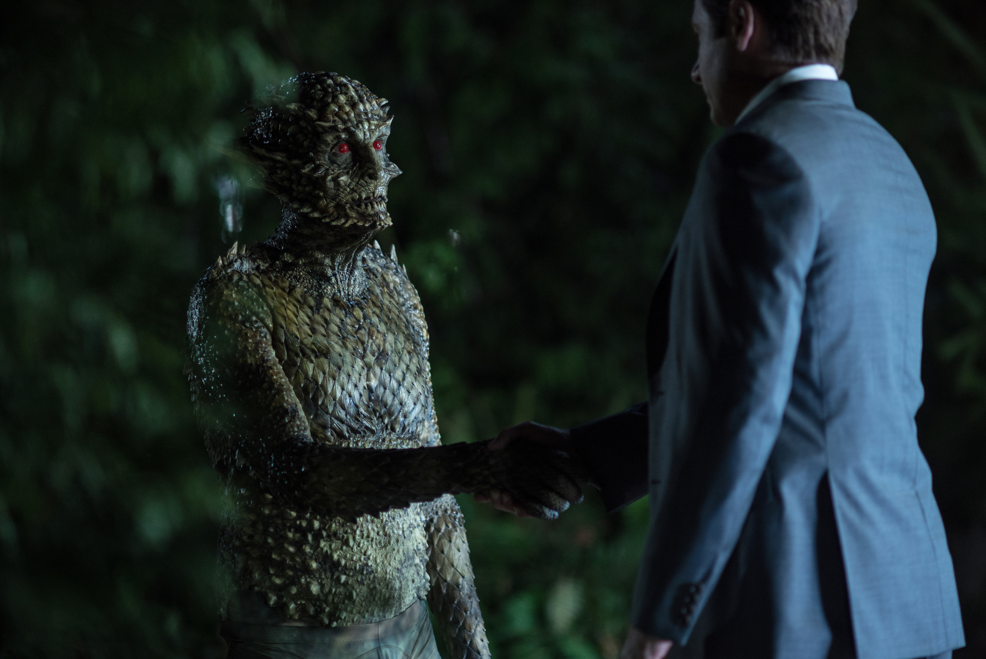 Reptilian creature and man in suit shaking hands HD Wallpaper