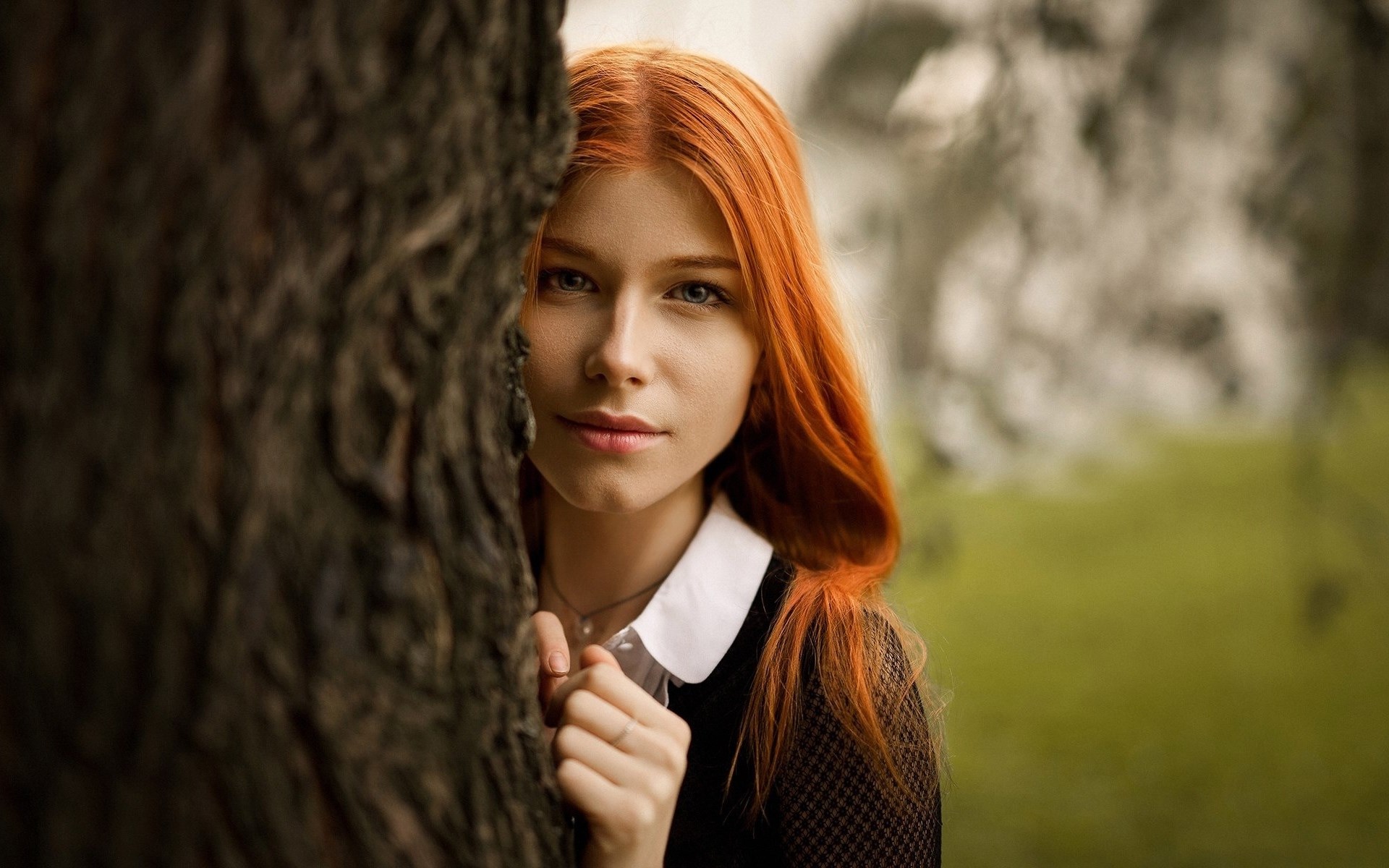 Young woman with red hair peeking from behind a tree HD Wallpaper