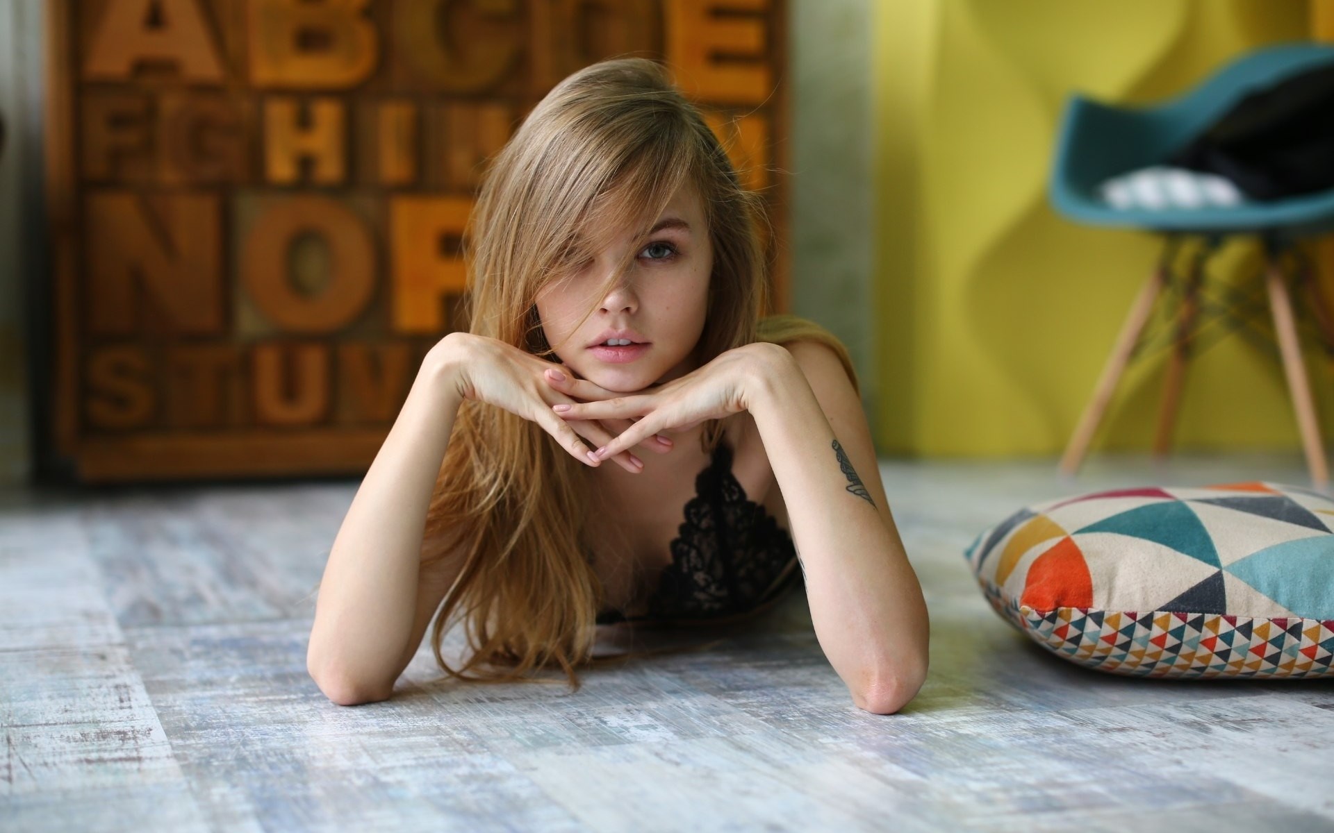 Woman lying on the floor with hands on chin HD Wallpaper