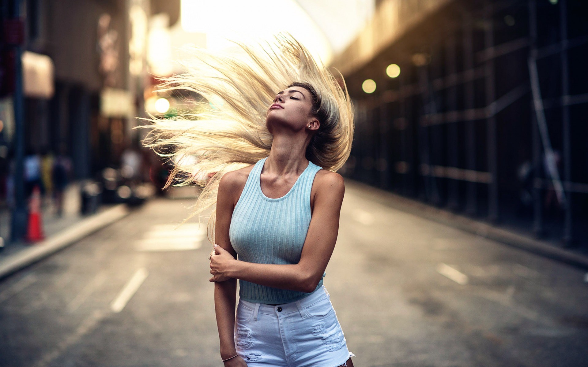 Woman with blonde hair flipping in a street HD Wallpaper