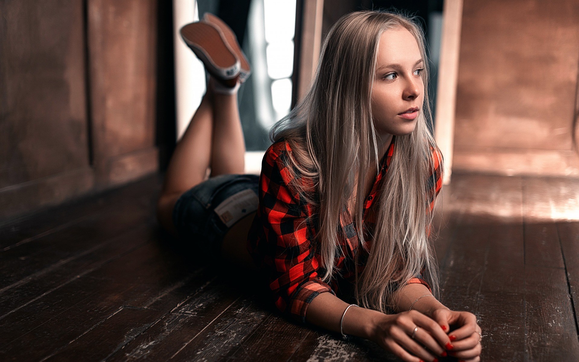 Woman in red plaid shirt and denim shorts lying on floor HD Wallpaper