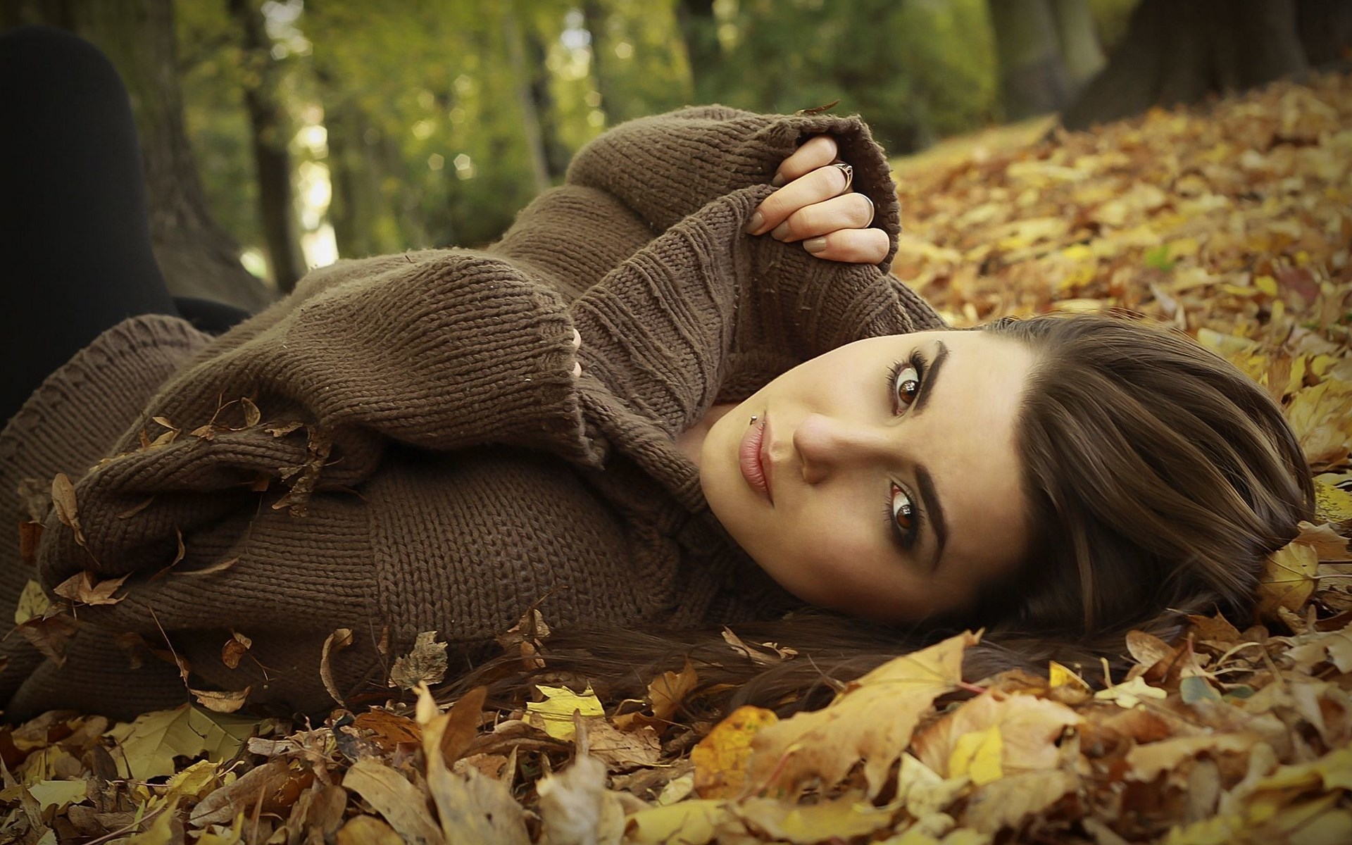 Woman lying in autumn leaves HD Wallpaper