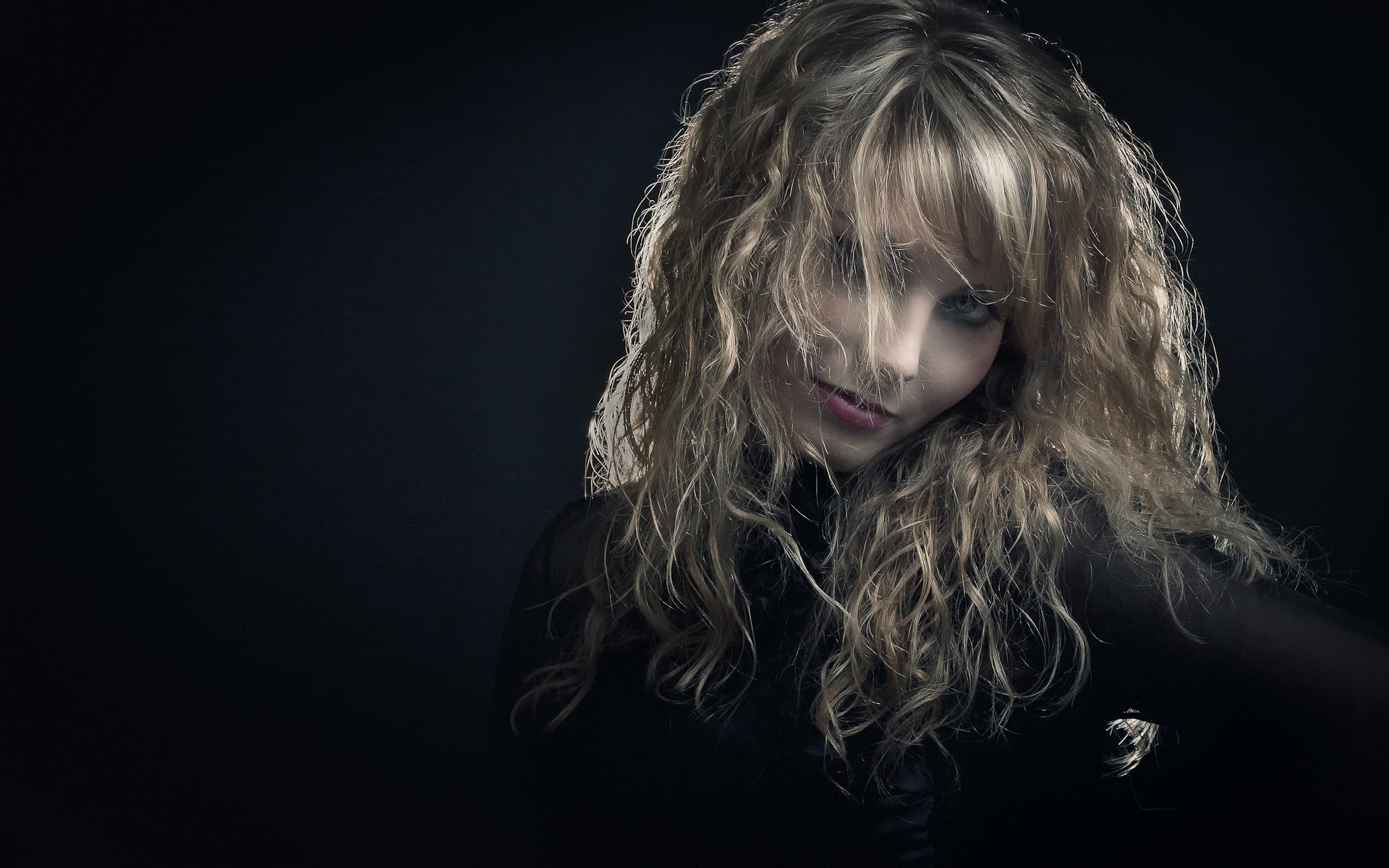 Woman with curly blonde hair in black clothing HD Wallpaper
