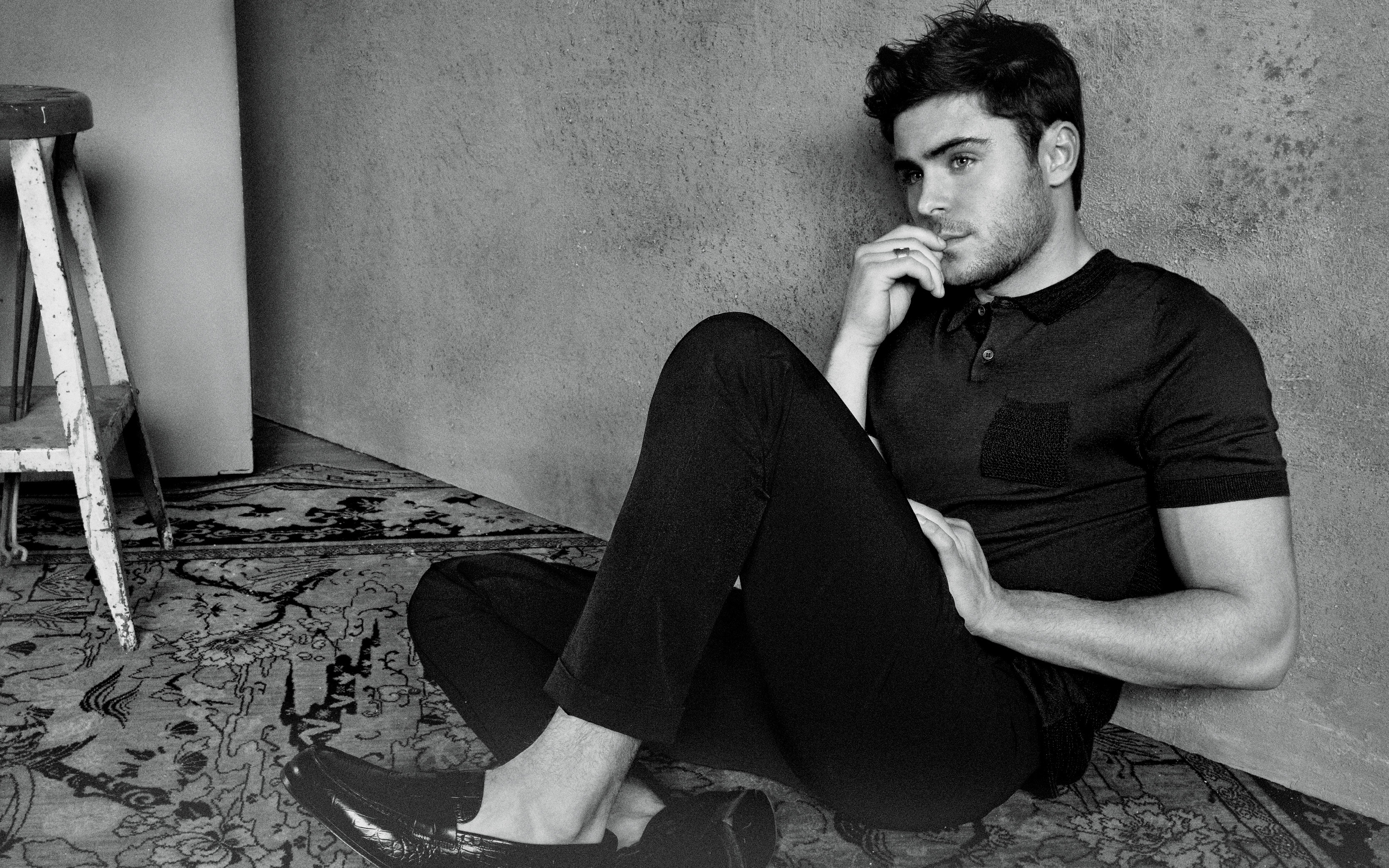 Zac Efron sitting on a rug HD Wallpaper