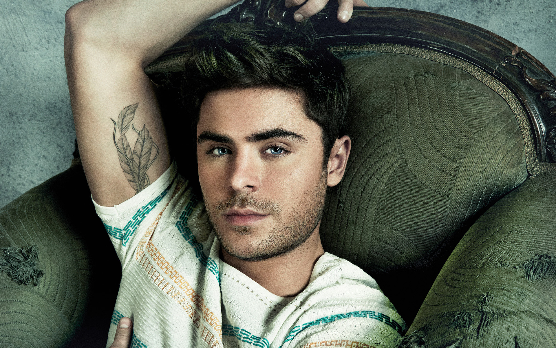 Zac Efron lying on a chair HD Wallpaper