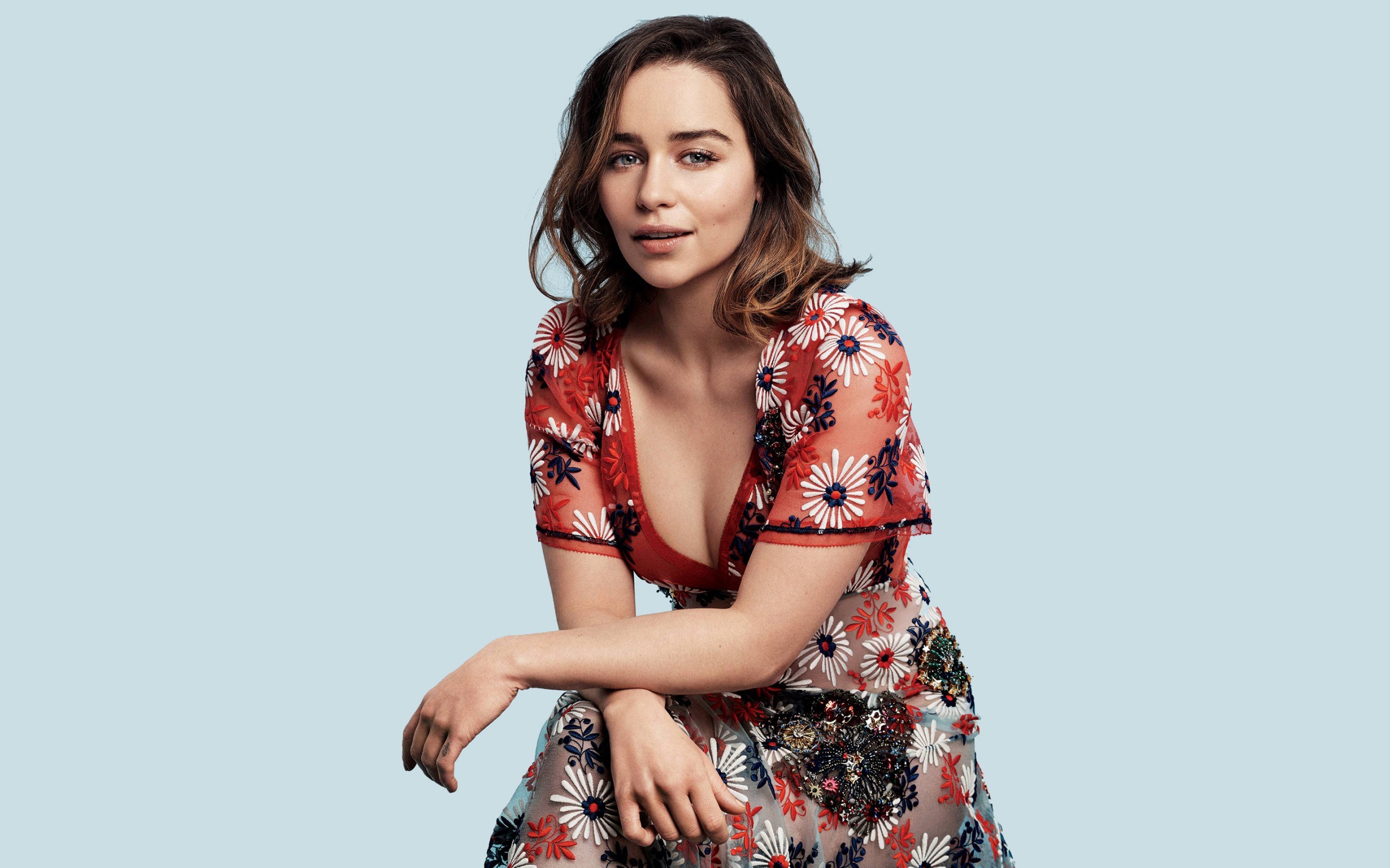 Emilia Clarke posing against a blue background HD Wallpaper