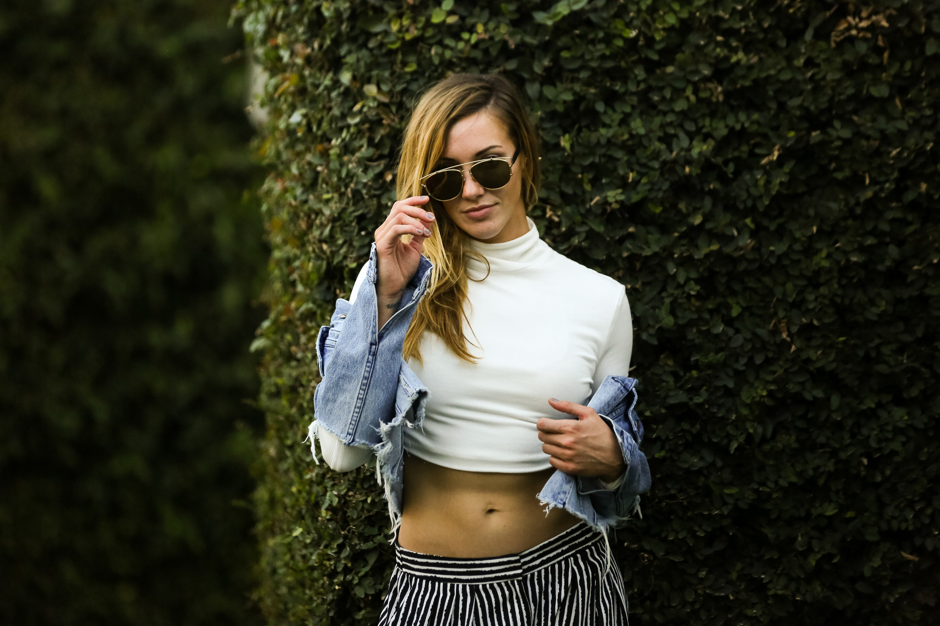 Katie Cassidy in a white crop top and denim jacket HD Wallpaper