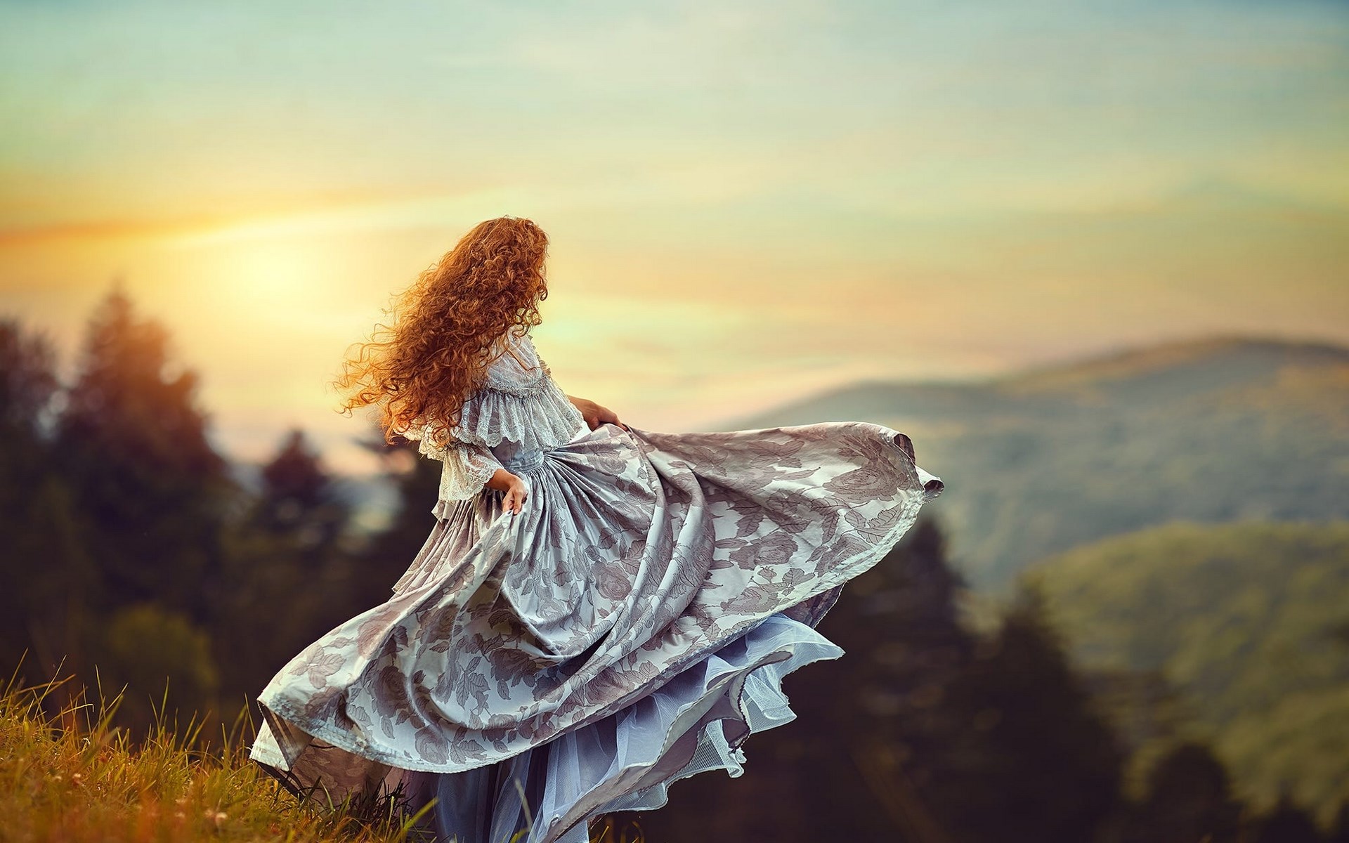 Woman in a flowing dress on a grassy hill HD Wallpaper
