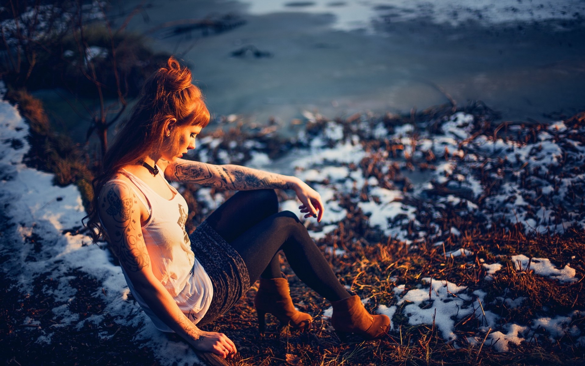 Woman with tattoos sitting by a frozen body of water HD Wallpaper
