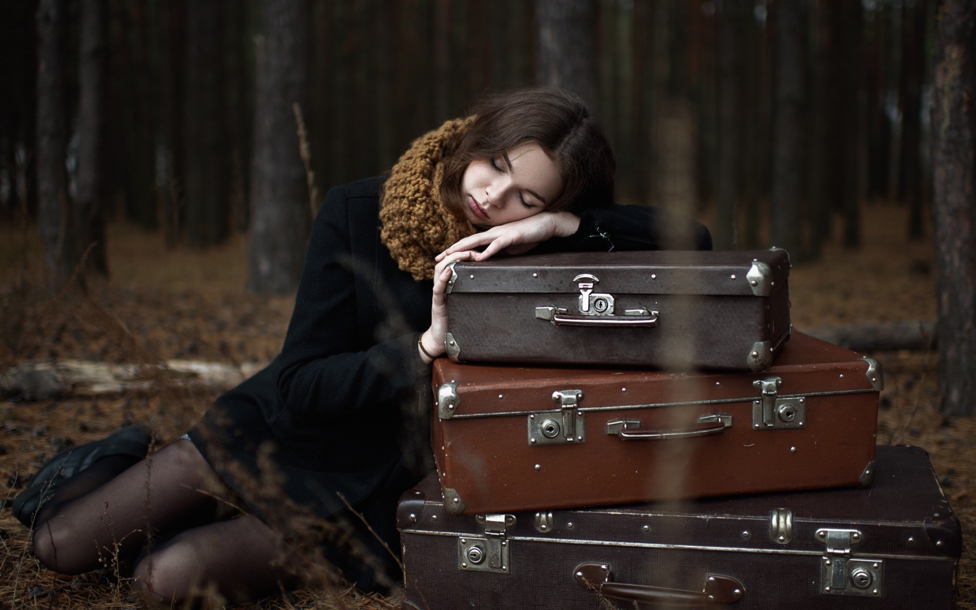 Woman sleeping on suitcases in a forest HD Wallpaper