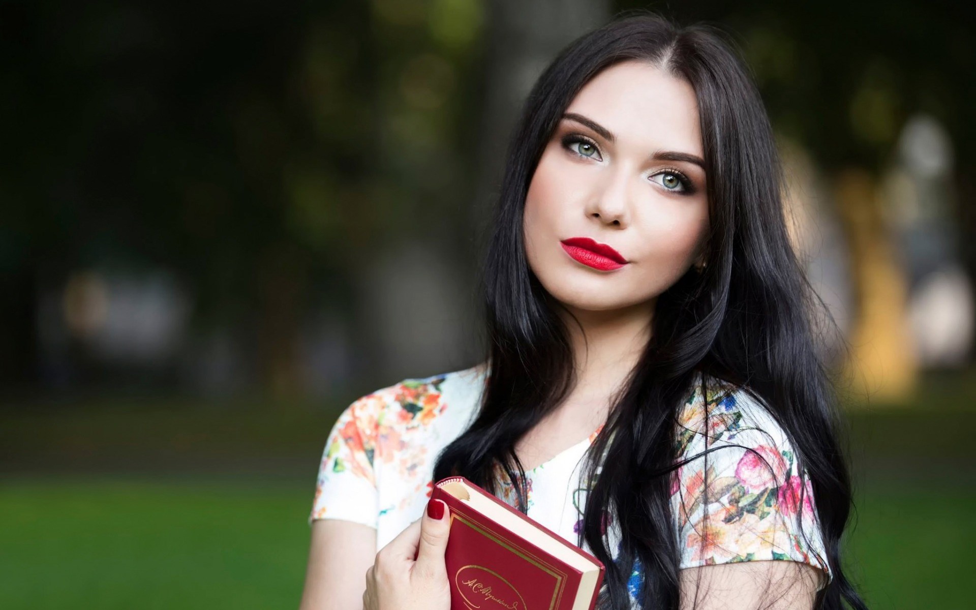 Woman holding a book in a park HD Wallpaper
