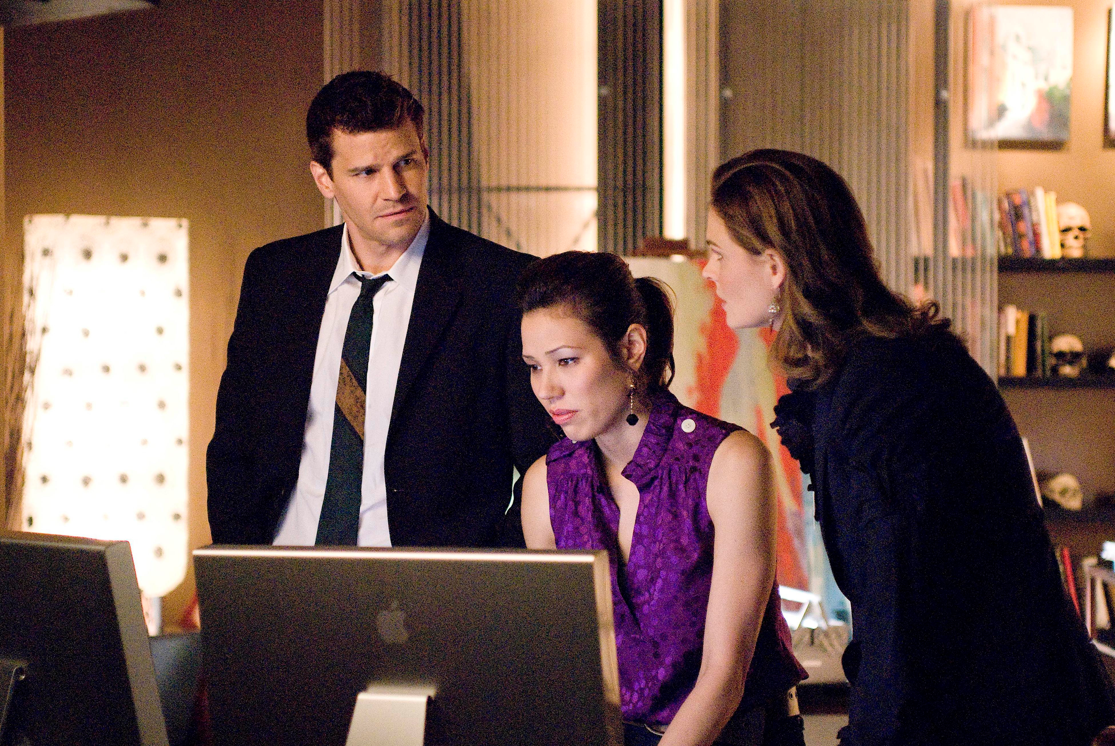 Michaela Conlin and two colleagues looking at a computer HD Wallpaper