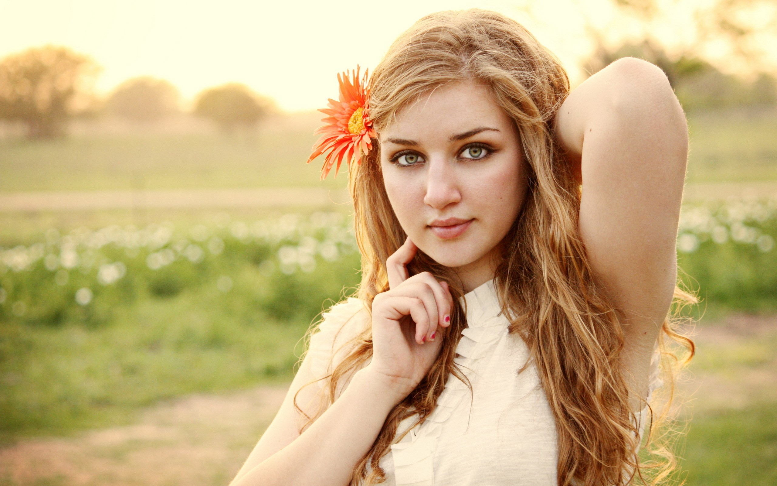 Young woman with orange flower in hair HD Wallpaper