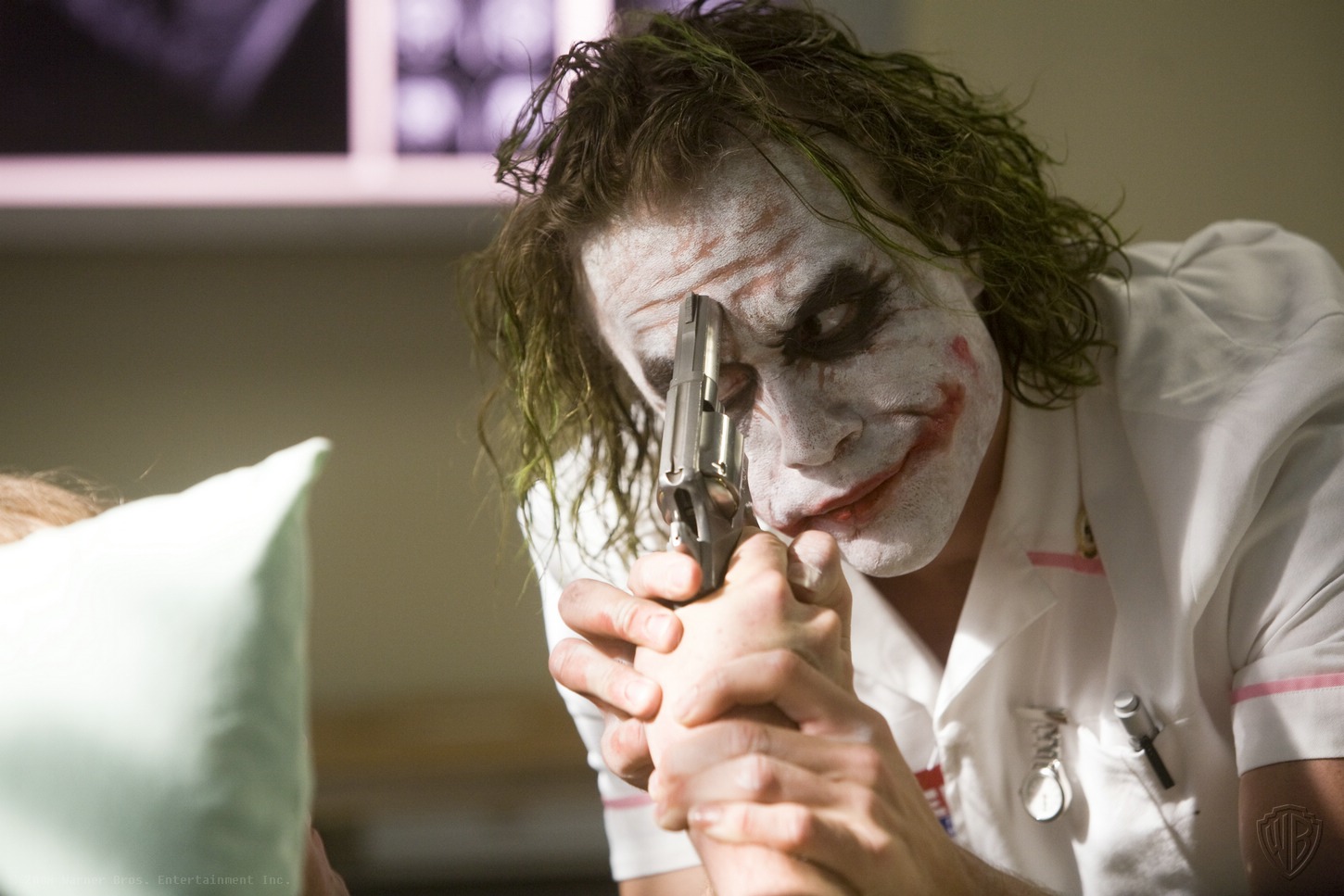 Heath Ledger as the Joker holding a gun HD Wallpaper
