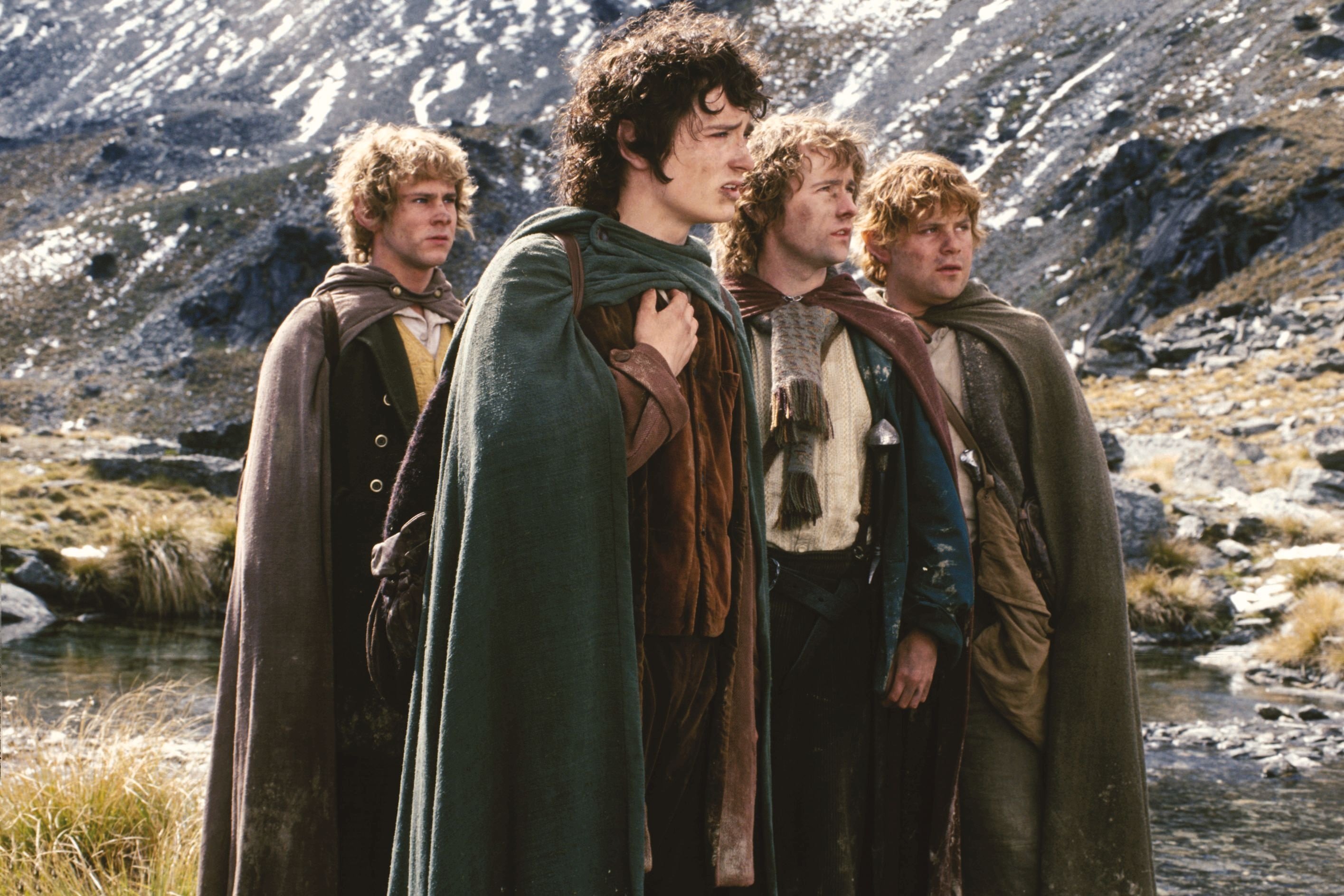 Four hobbits from The Lord of the Rings in a mountainous landscape HD Wallpaper