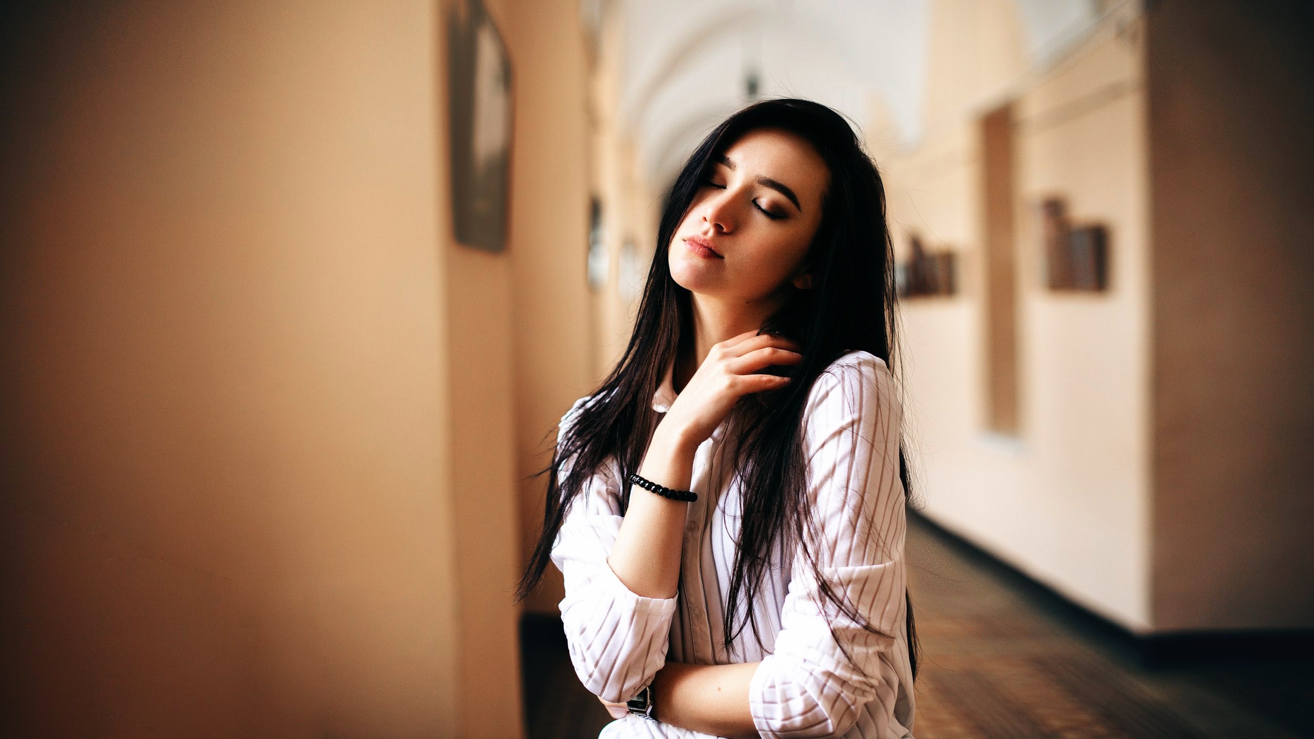 Woman with eyes closed in a hallway HD Wallpaper
