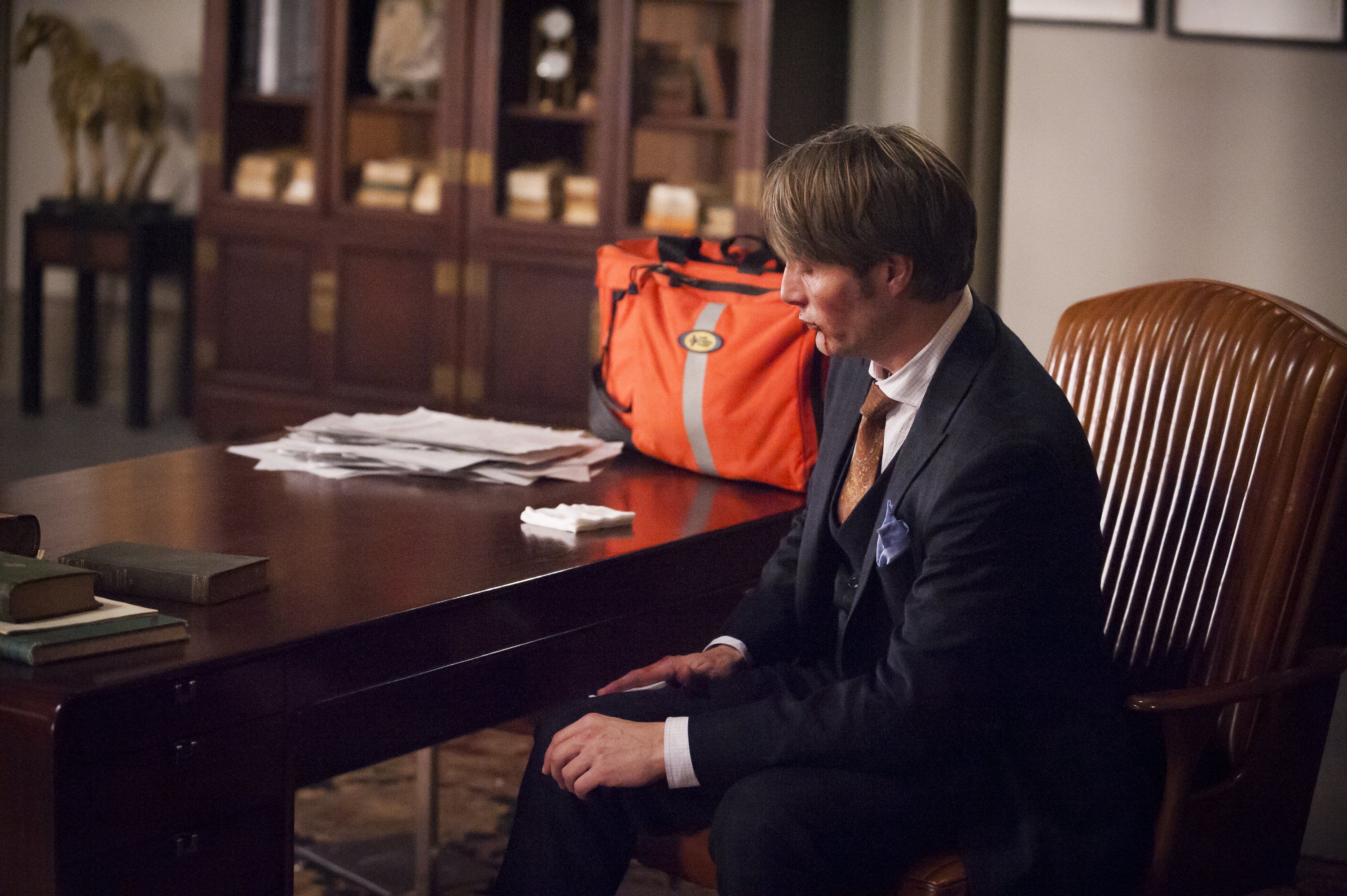 Mads Mikkelsen in a suit sitting at a desk HD Wallpaper