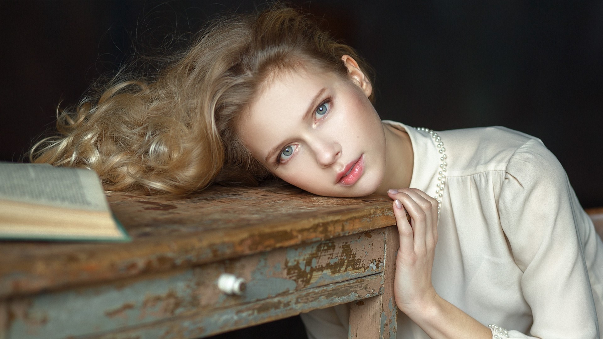Young woman resting head on a wooden table HD Wallpaper
