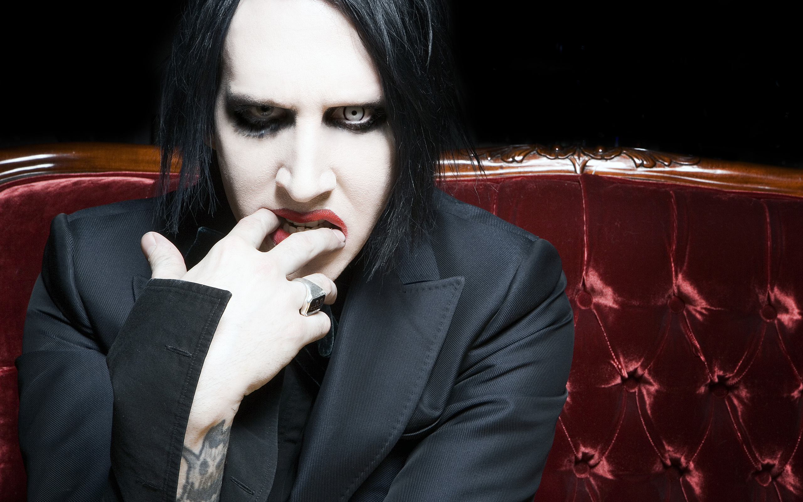 Marilyn Manson on a red couch HD Wallpaper