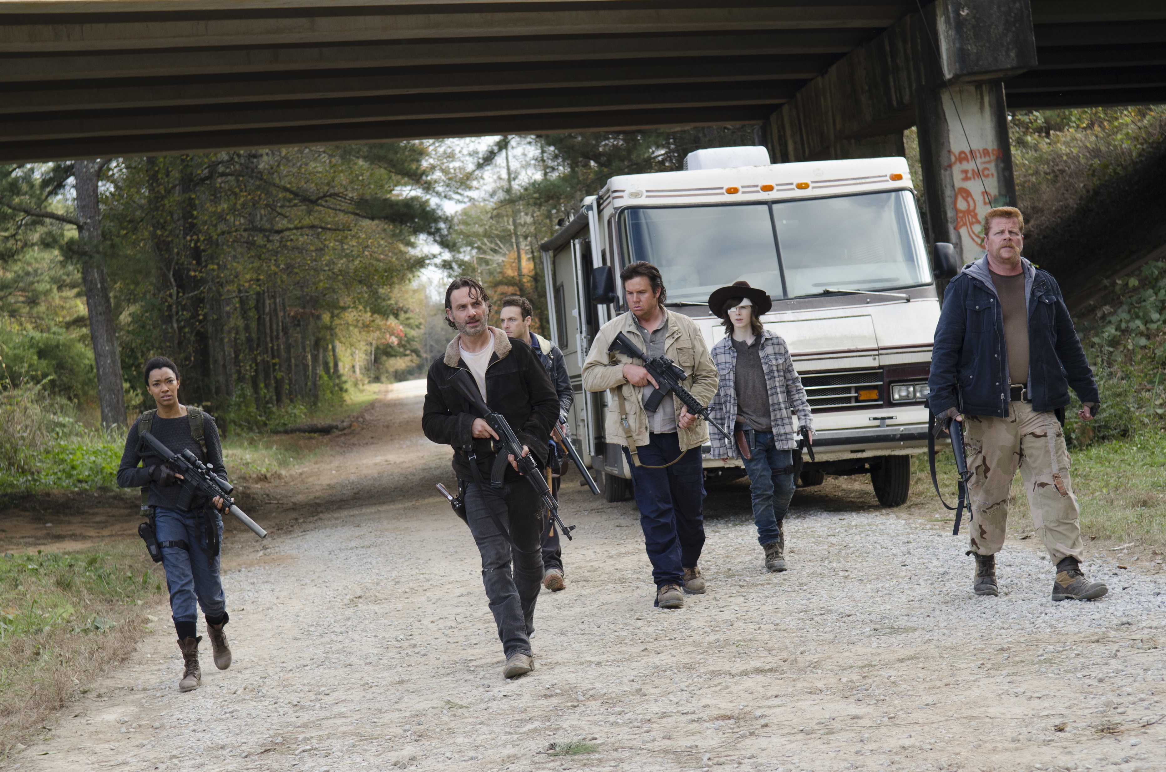 The Walking Dead characters walking on a road HD Wallpaper