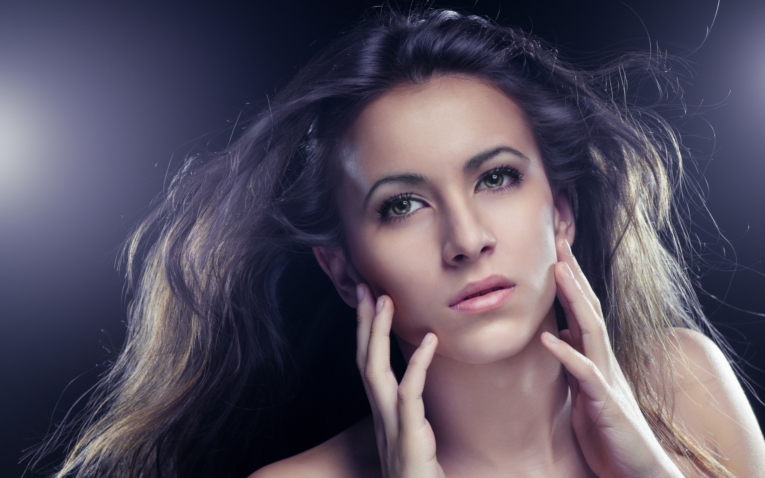 Woman with flowing hair and hands on face HD Wallpaper