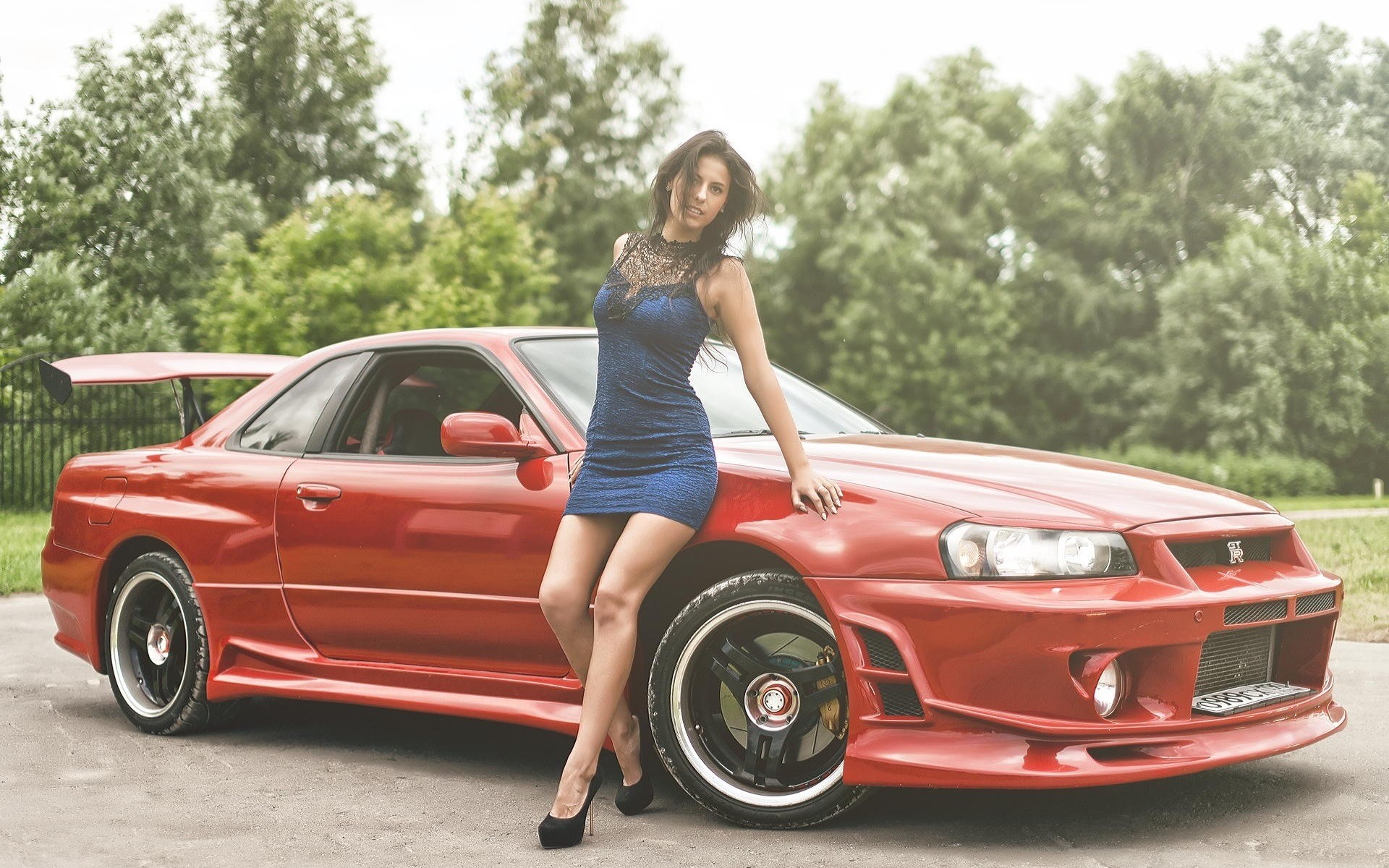 Woman in blue dress leaning on red sports car HD Wallpaper