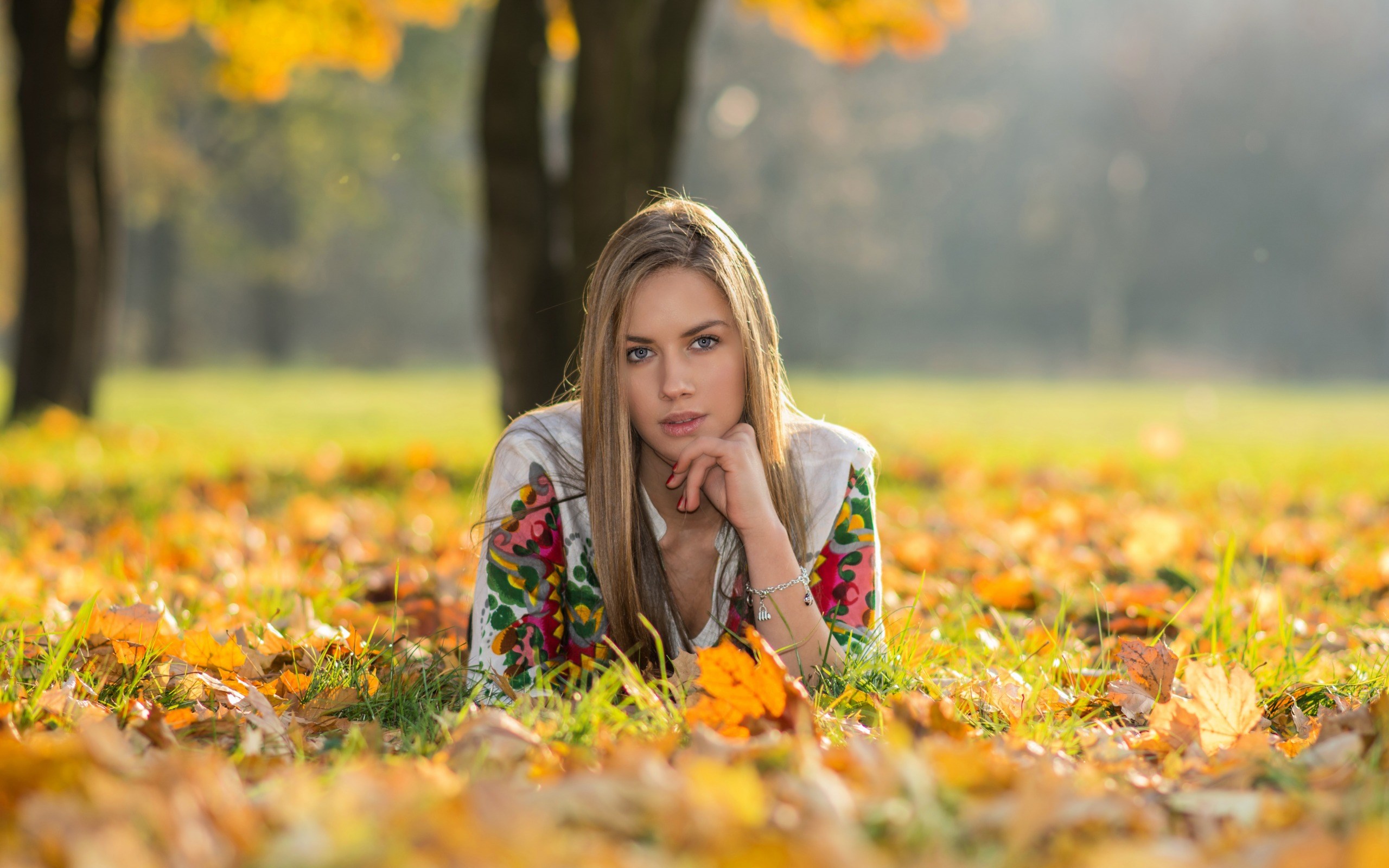 Woman lying in autumn leaves HD Wallpaper