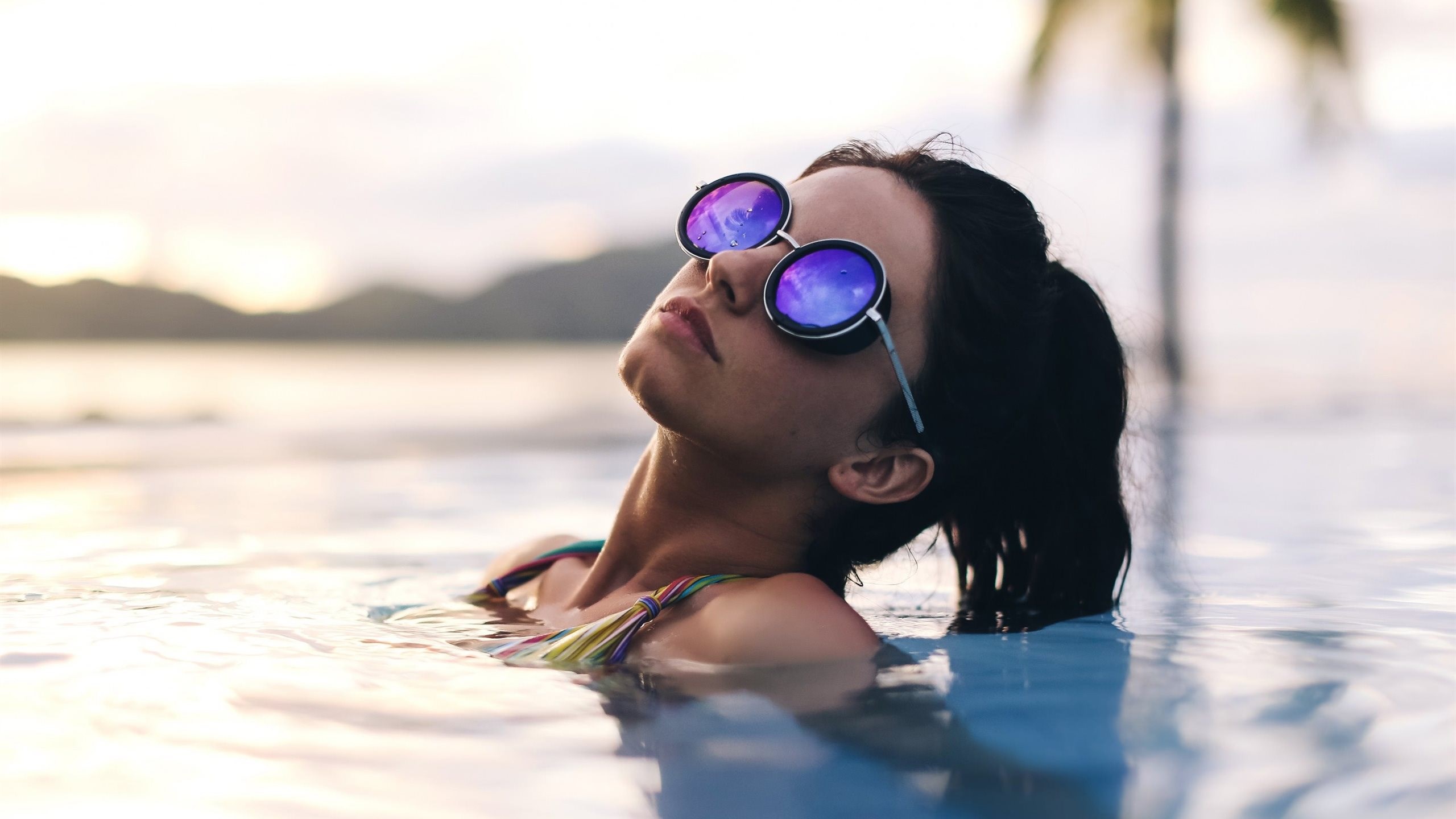 Woman in sunglasses in a pool at sunset HD Wallpaper