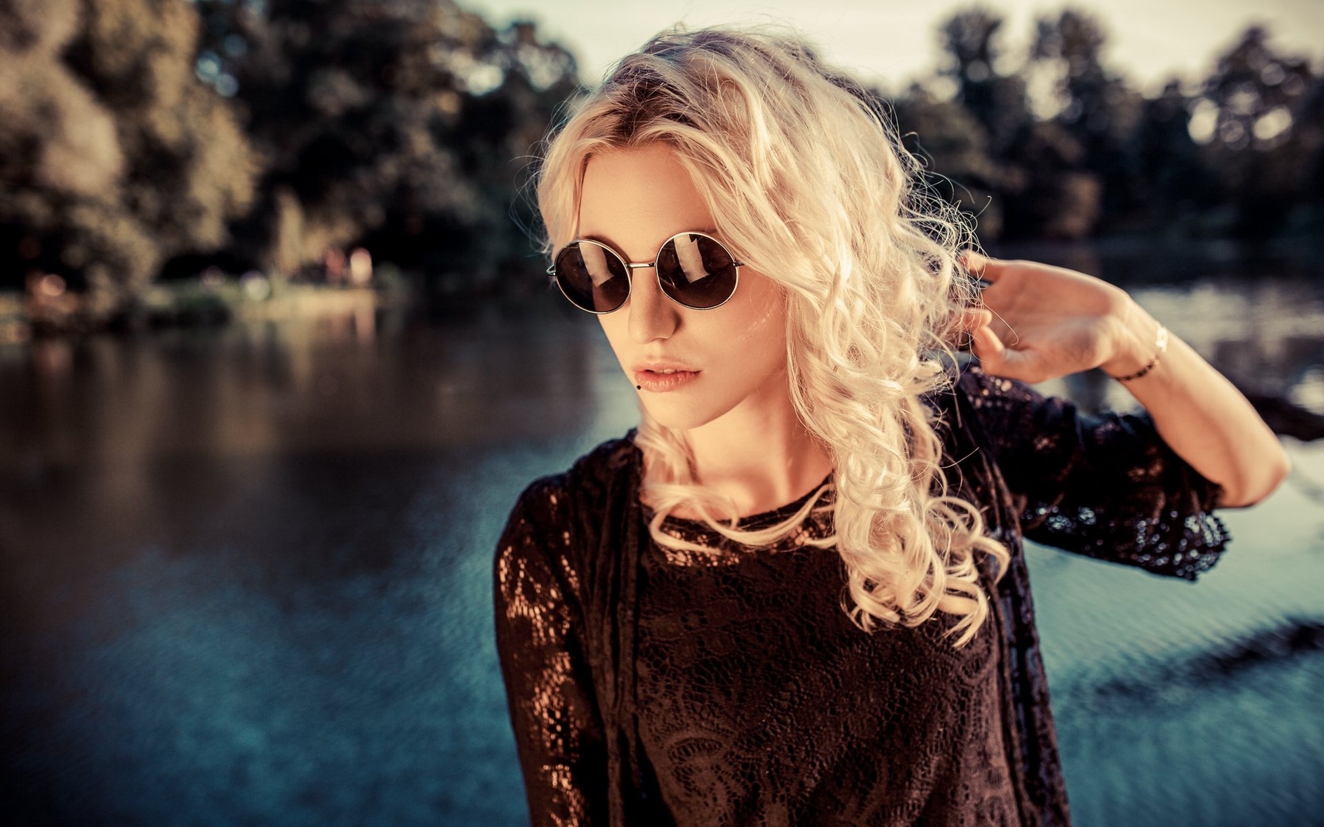 Woman with blonde curly hair and sunglasses by the water HD Wallpaper