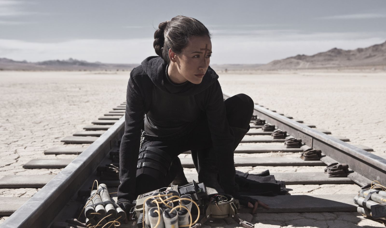 Maggie Q on train tracks with explosives HD Wallpaper