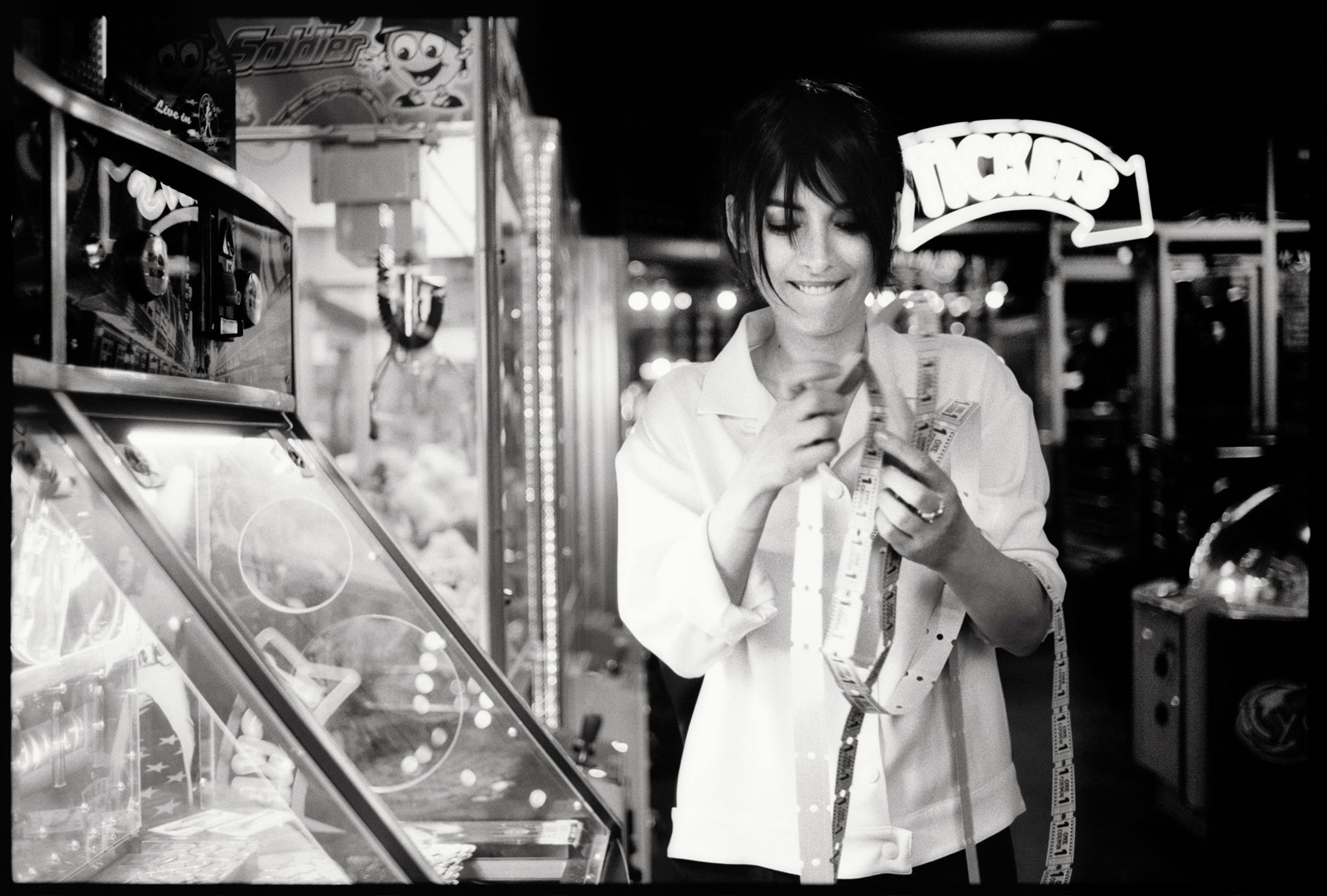 Winona Ryder holding tickets in an arcade HD Wallpaper
