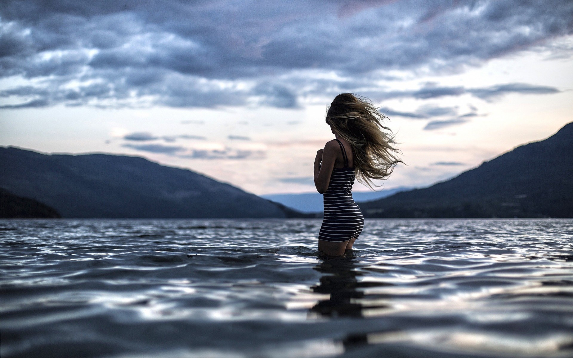 Woman in striped dress standing in water at dusk HD Wallpaper